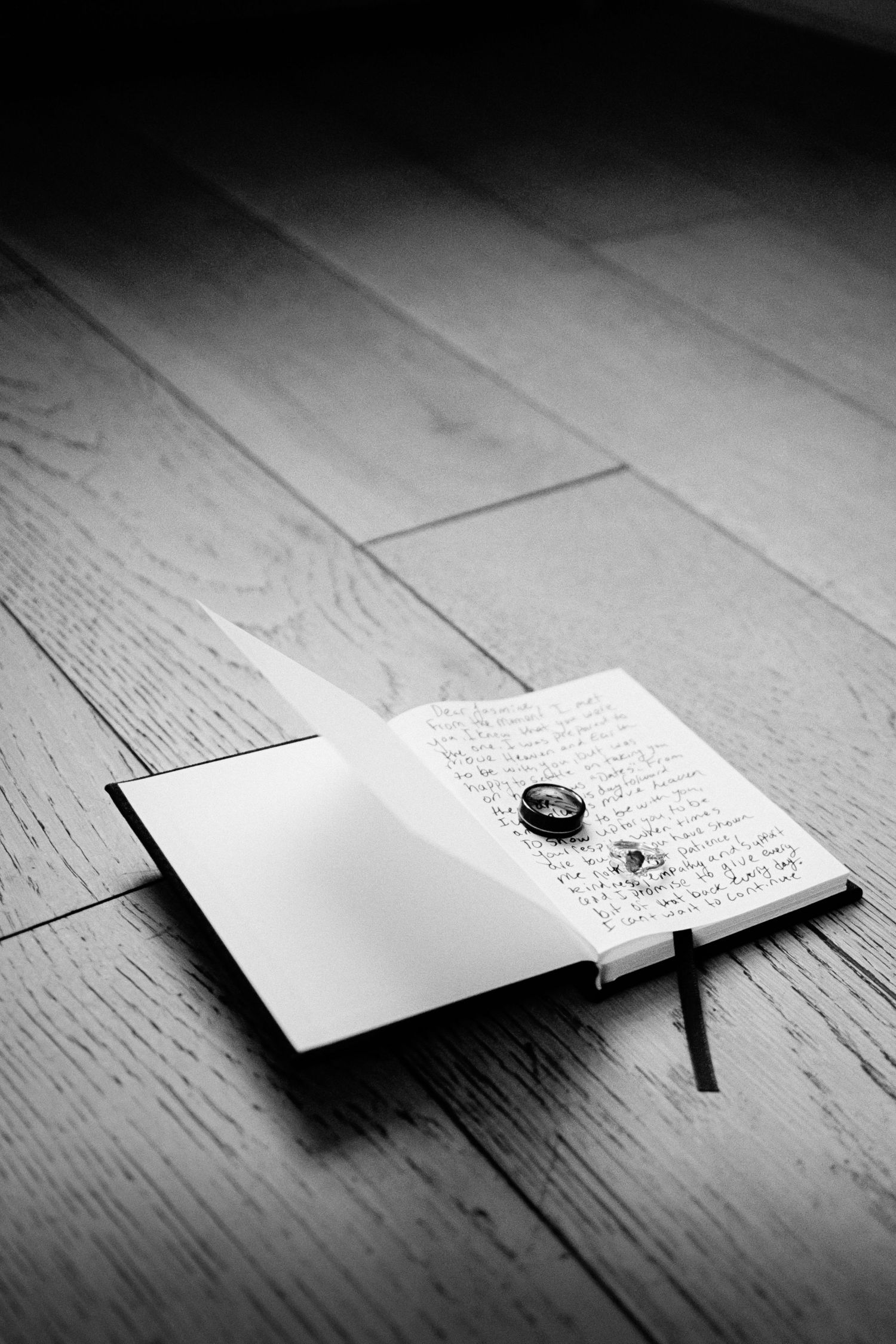Black and white photo sequence showing a handwritten letter on wooden floor gradually fading into darkness.