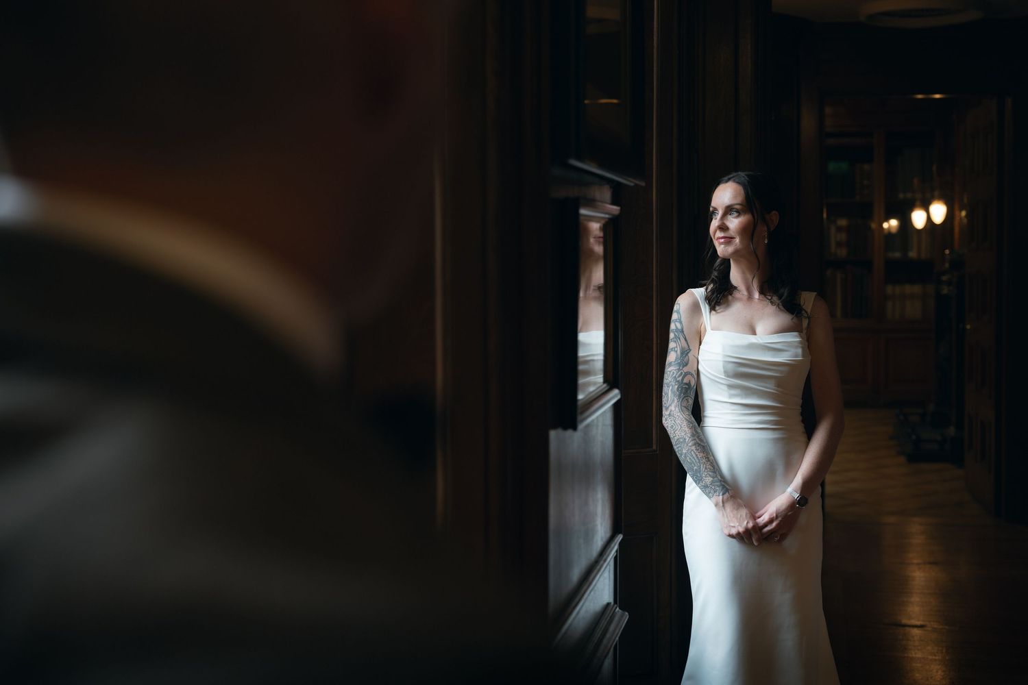 A series of moody wedding photos showing a bride in a white dress in various dark, dramatic indoor settings.