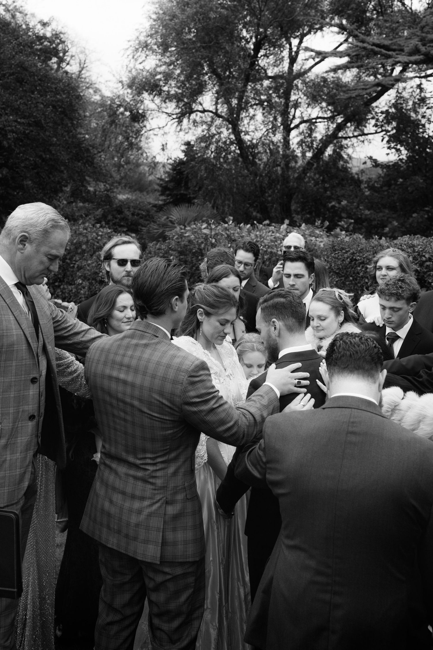 A sequence of black and white photos showing a group of people at an outdoor gathering interacting and socializing.