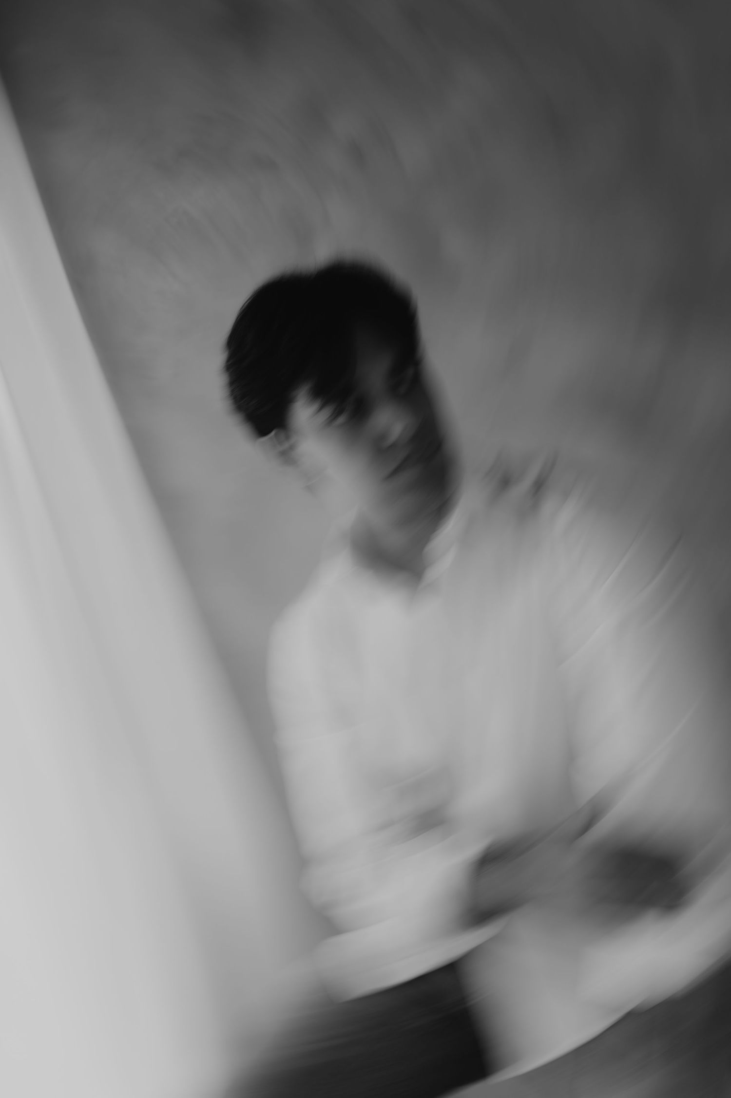Abstract motion blur black and white portrait of a young man creating dreamy artistic effect.