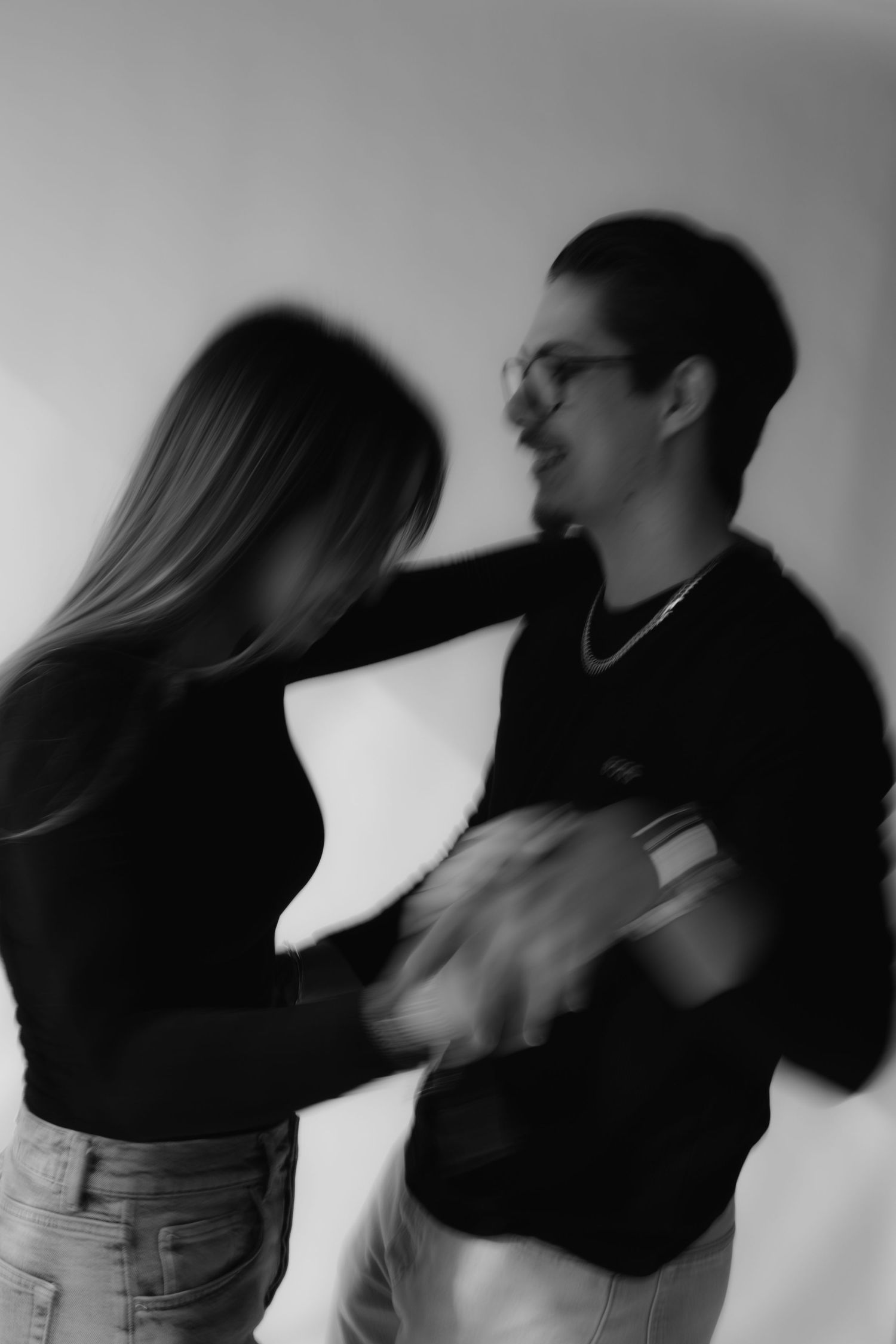 Blurred black and white photo of a couple dancing together, capturing motion and energy.