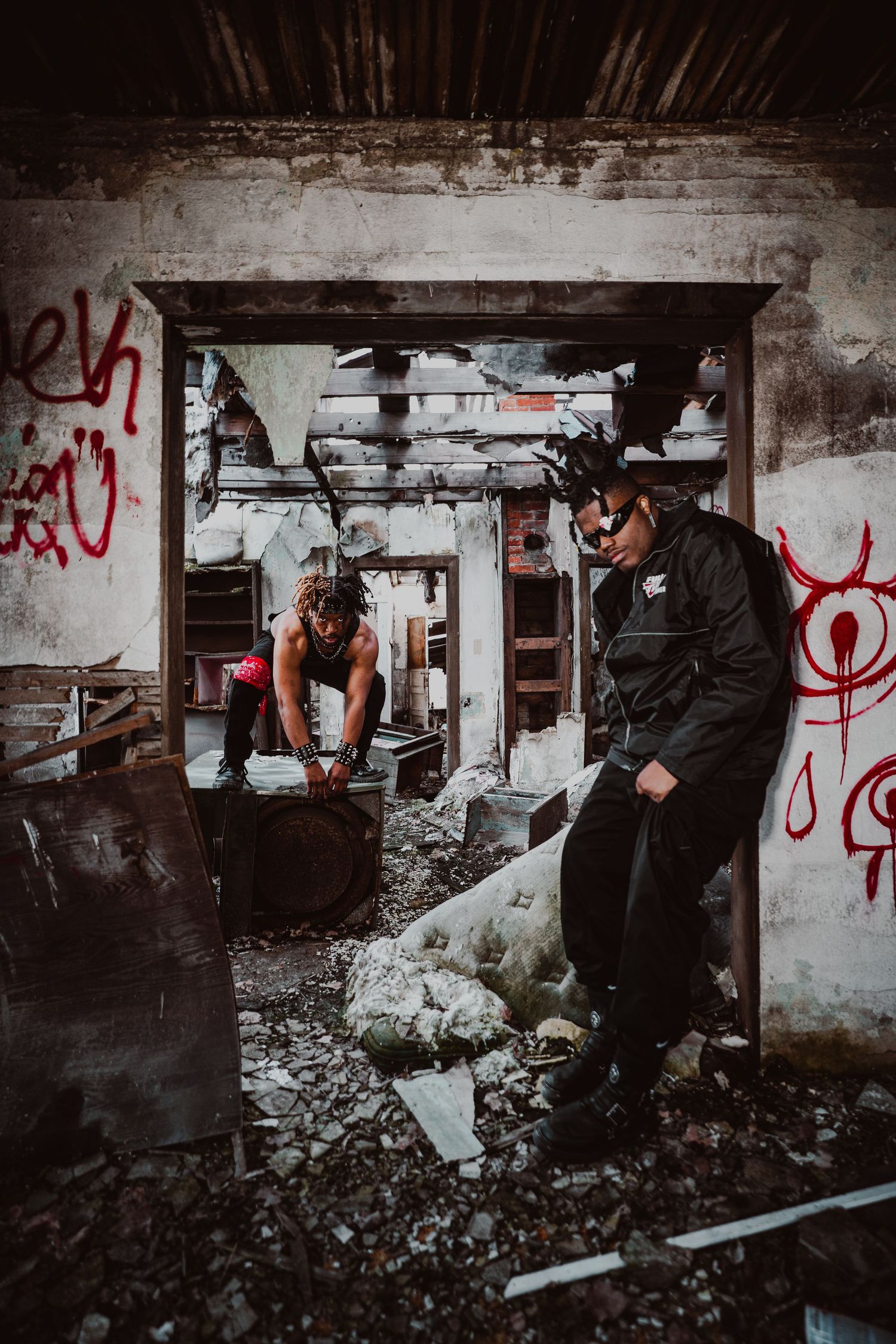 Environmental portrait of BLXCKPUNKS in an abandoned house covered with debris and graffiti