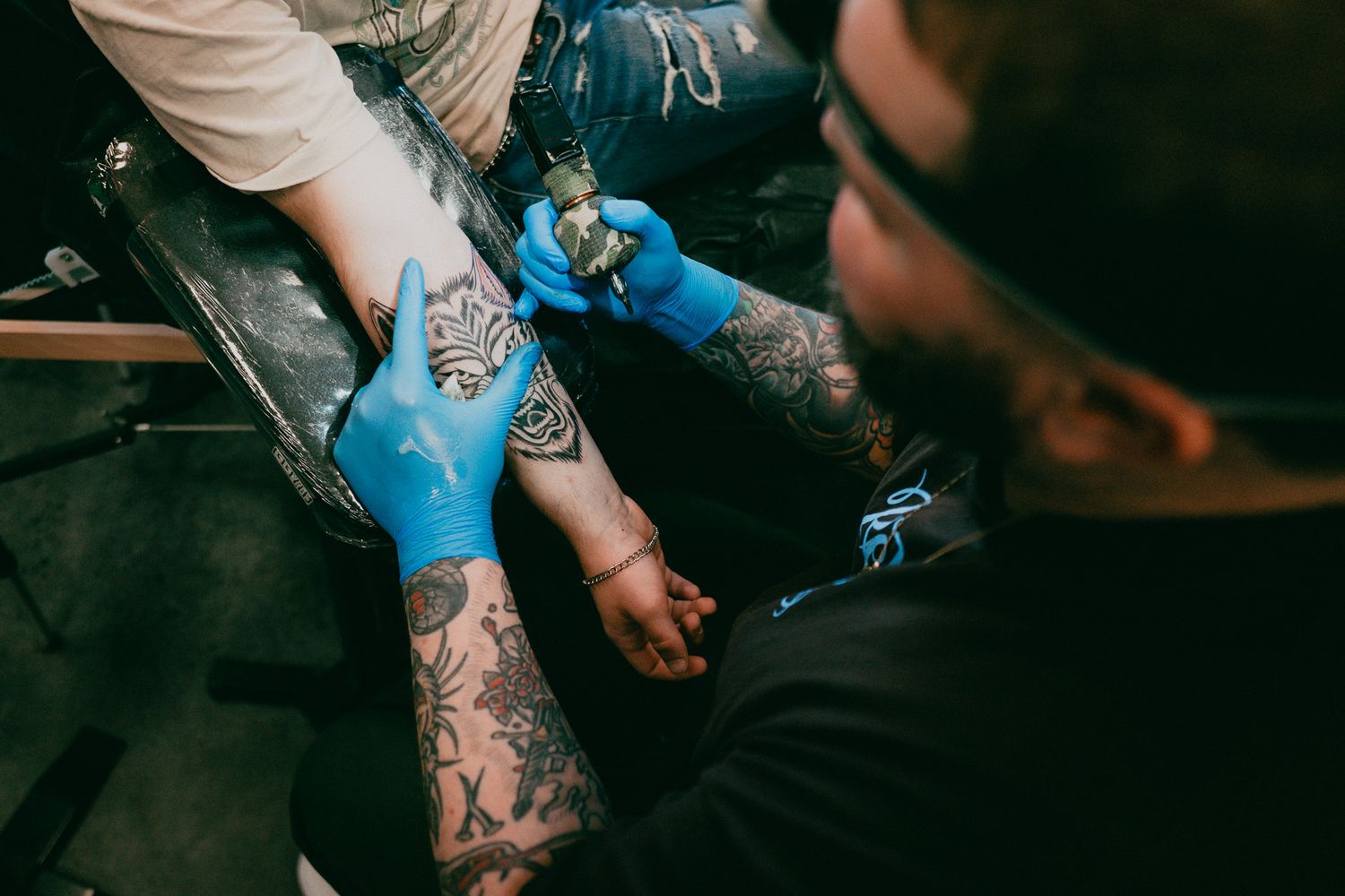 An overhead shot of a tattoo artist working on a wolf tattoo