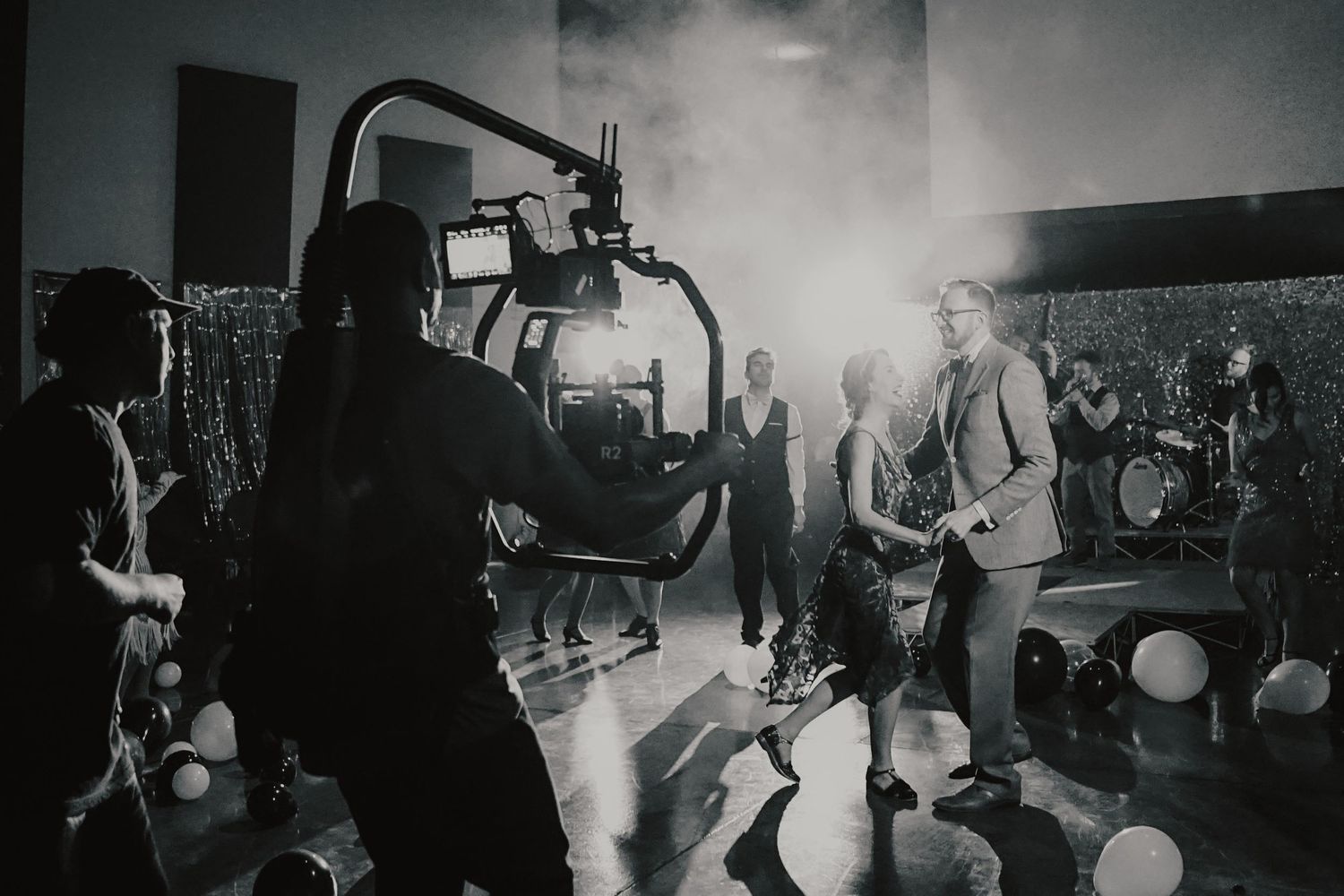 Behind the scenes image of a party while camera man operates camera attached to his body