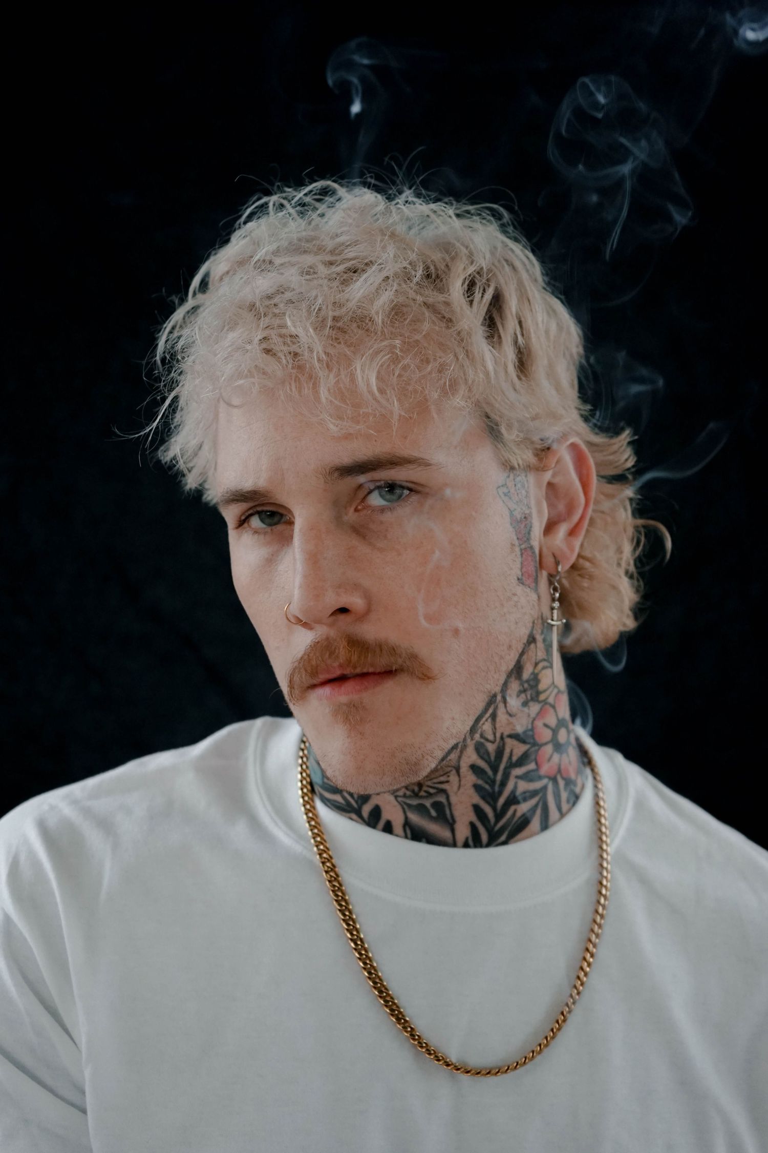 Man with neck tattoos and blonde hair