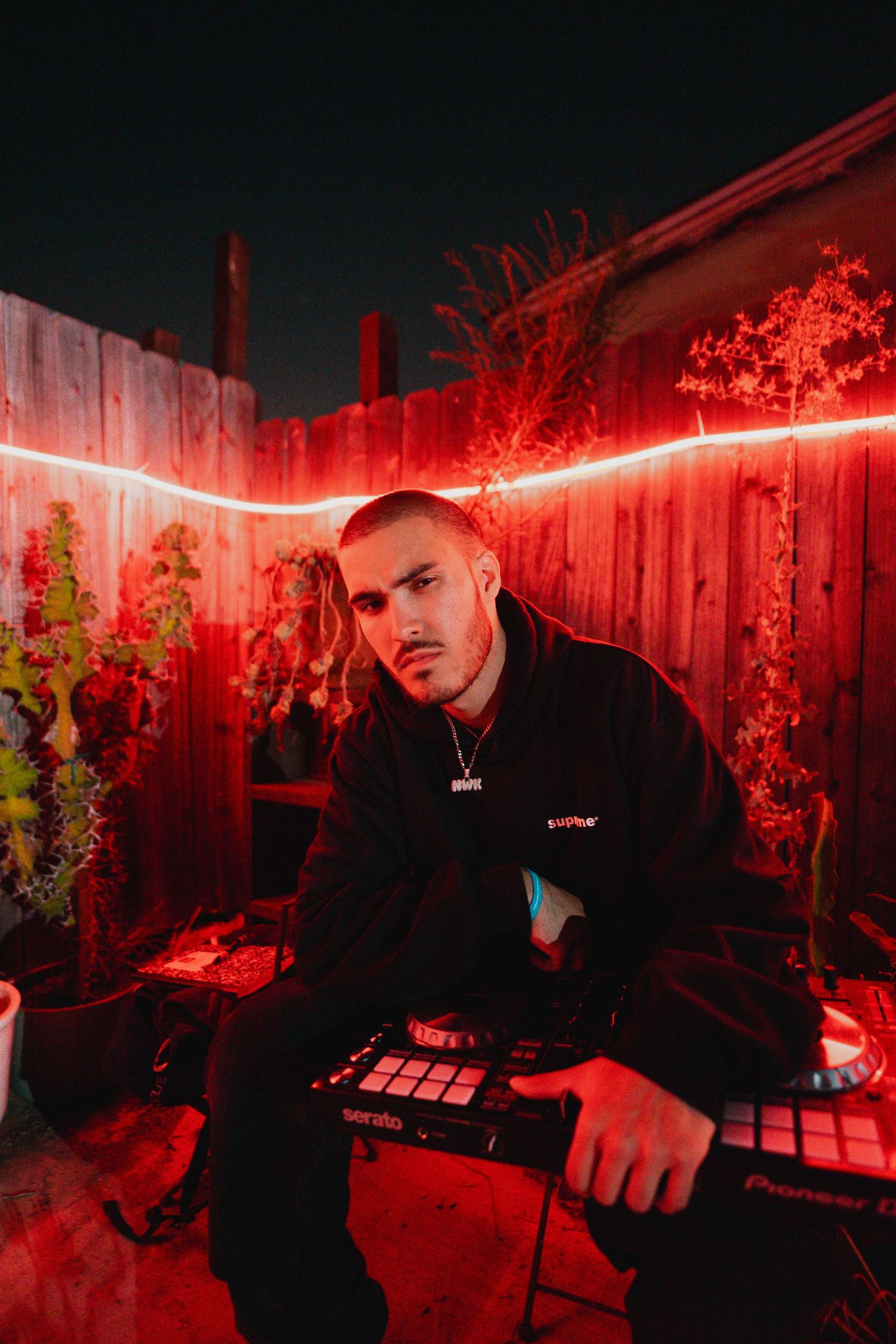Portrait of man sitting in red ambient lighting with a keyboard on his lap