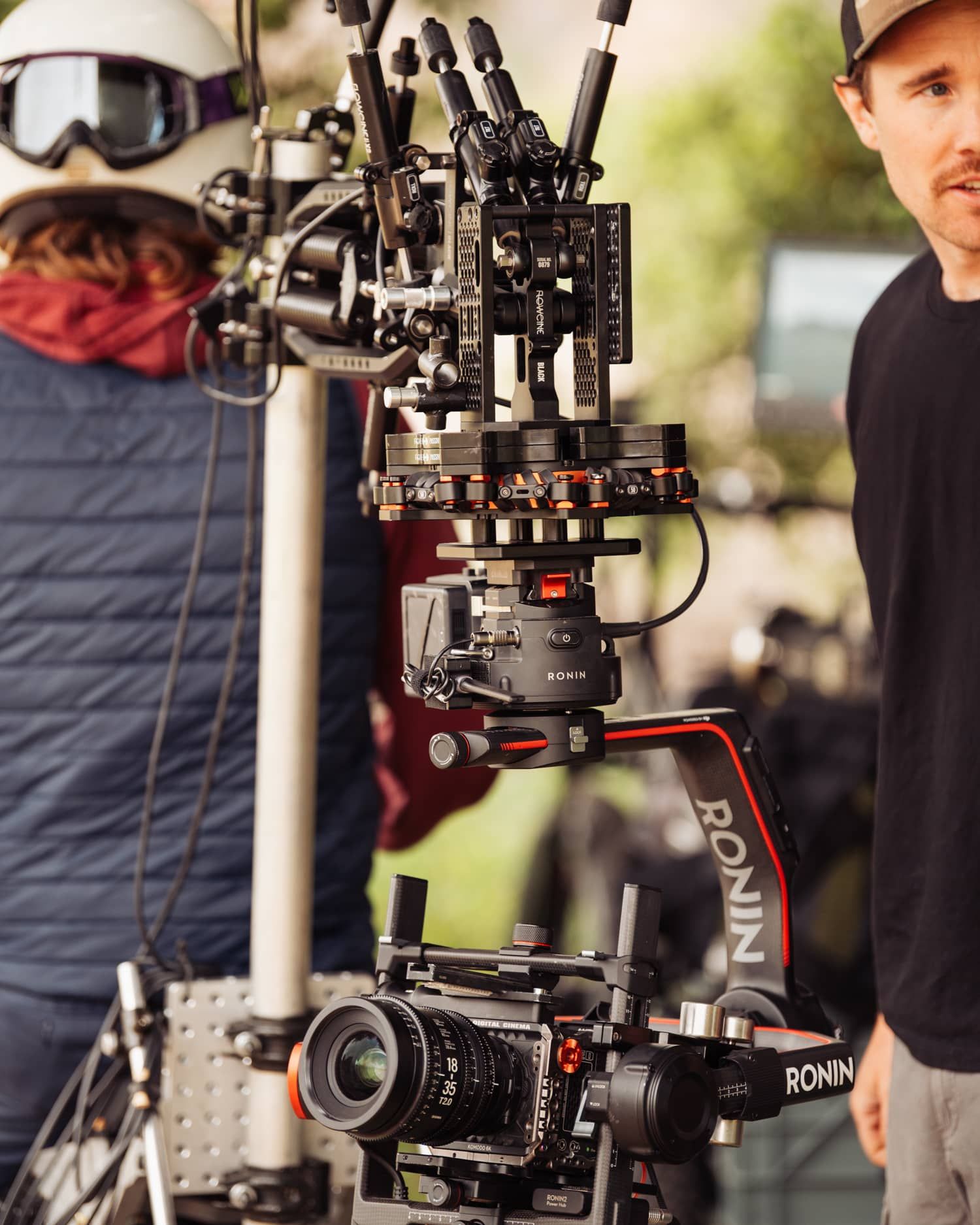 A DJI Ronin camera stabilizer rig being tested on a film set with crew members in the background.