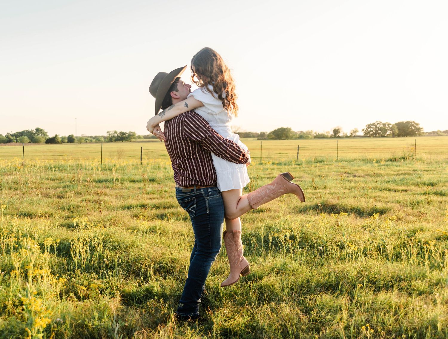 a man has picked up a woman as she kicks her foot back in excitement