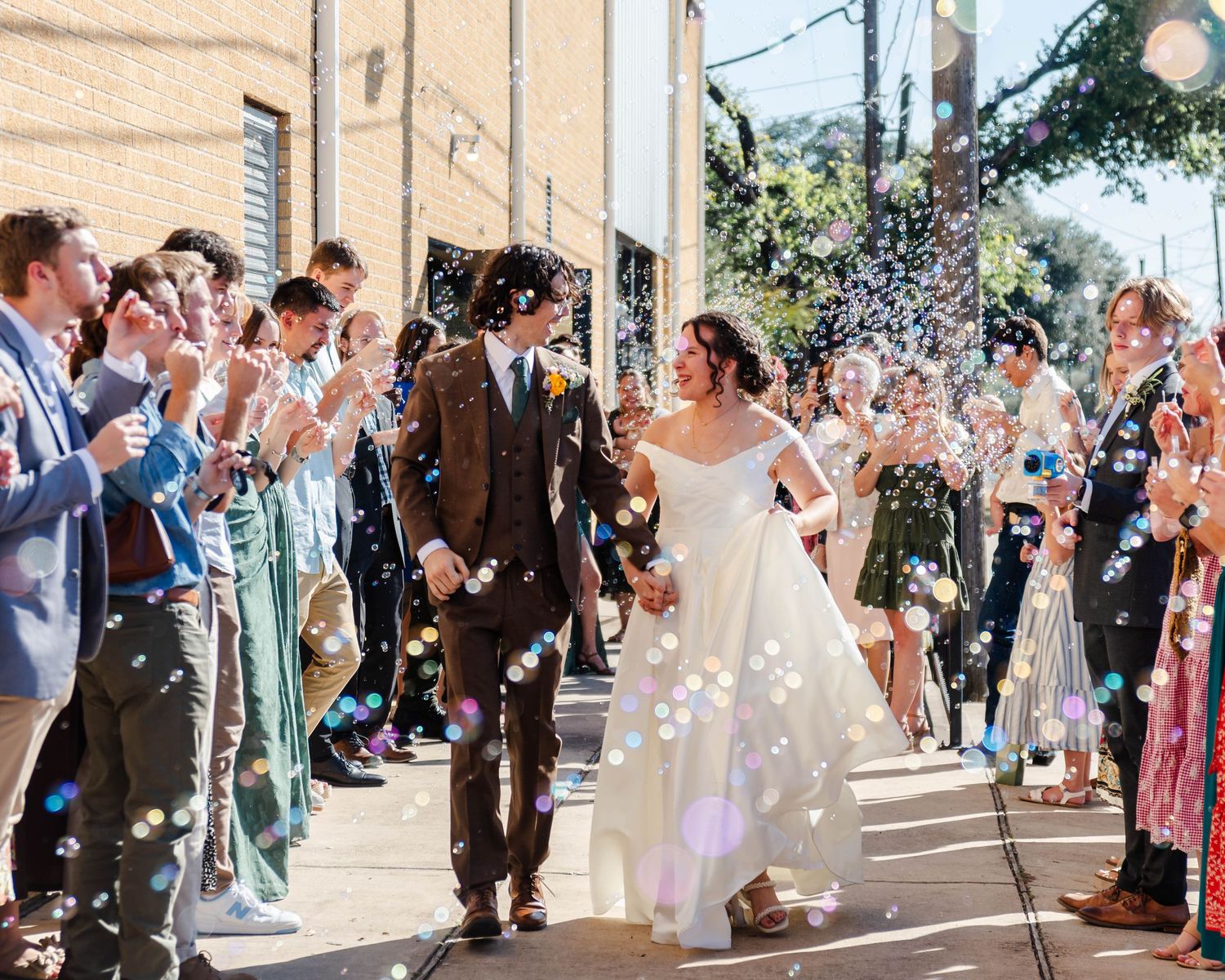 a couple exits their wedding with bubbles