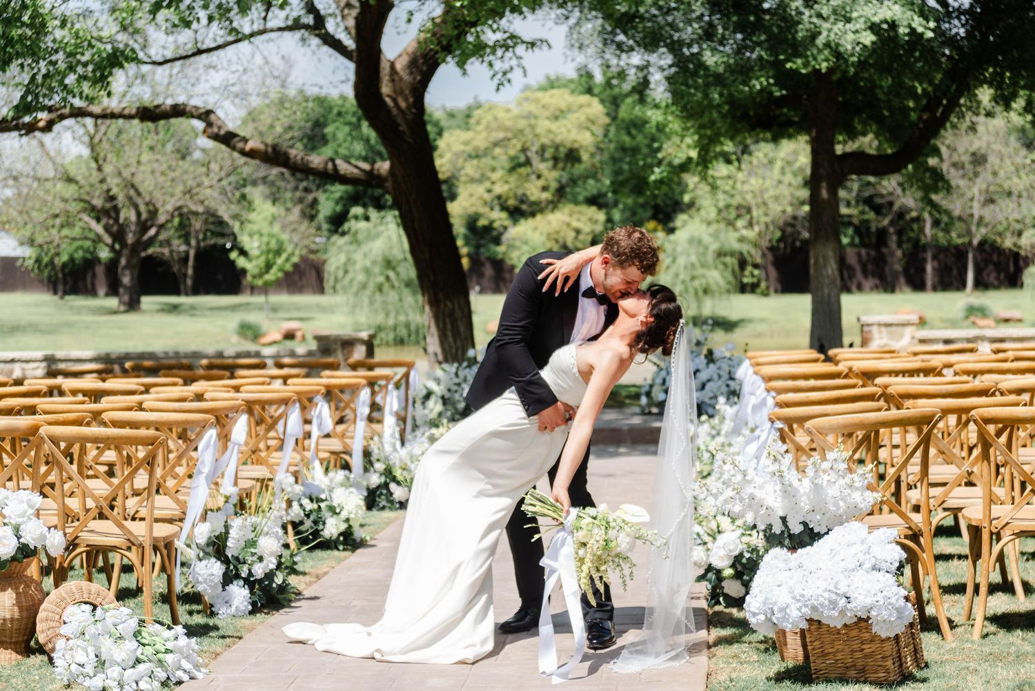couple in dip pose at ceremony with white