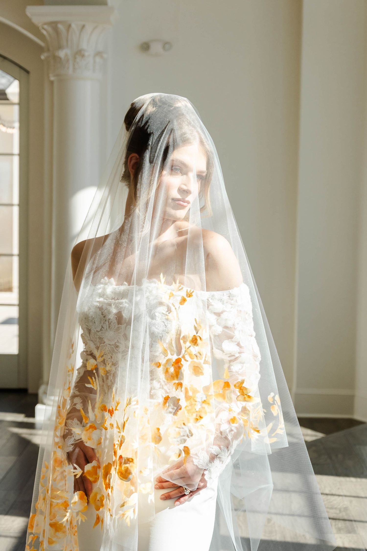 Bride with a veil on that has yellow painted flowers