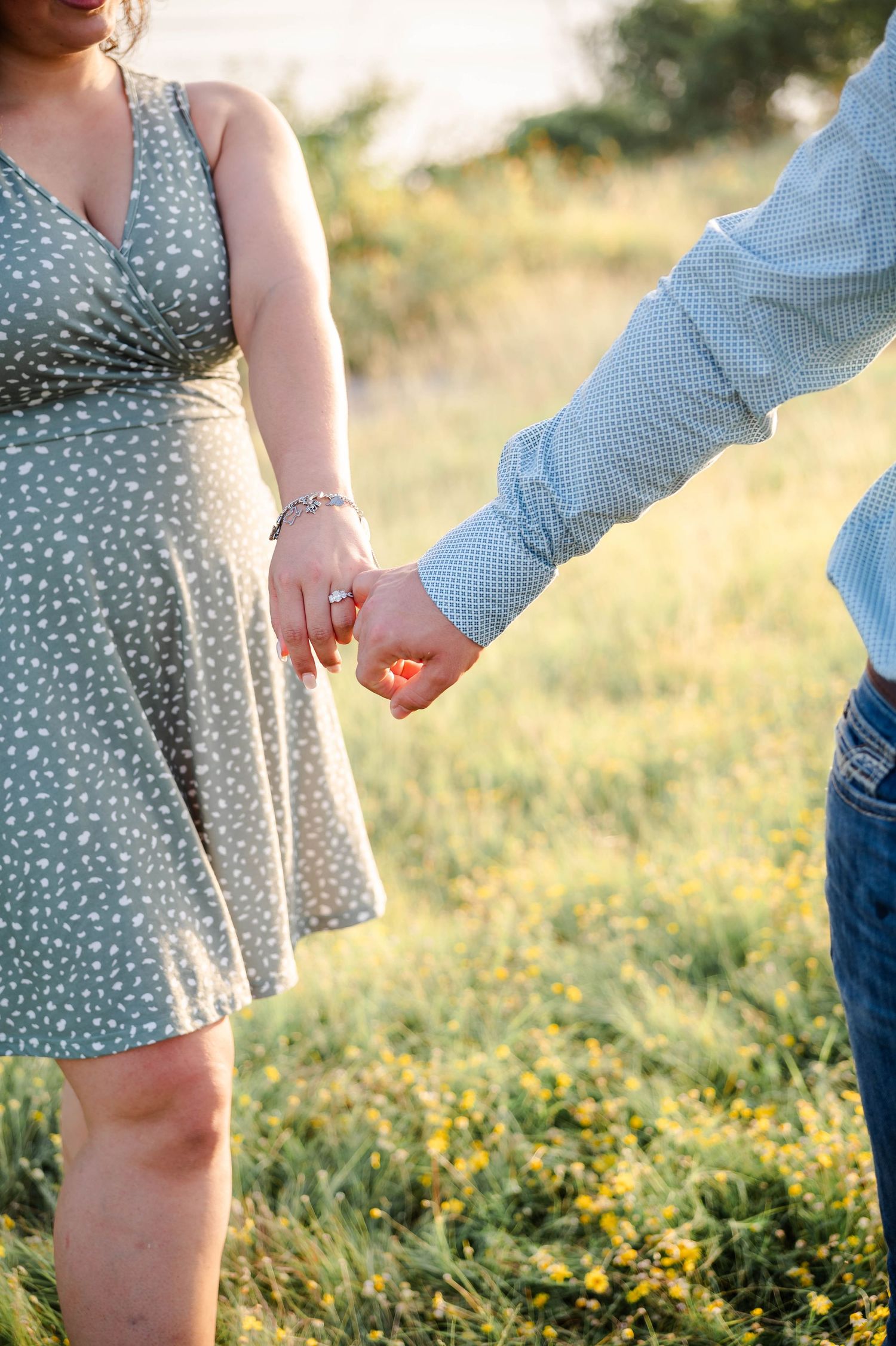 couple is holding pinkies as they walk