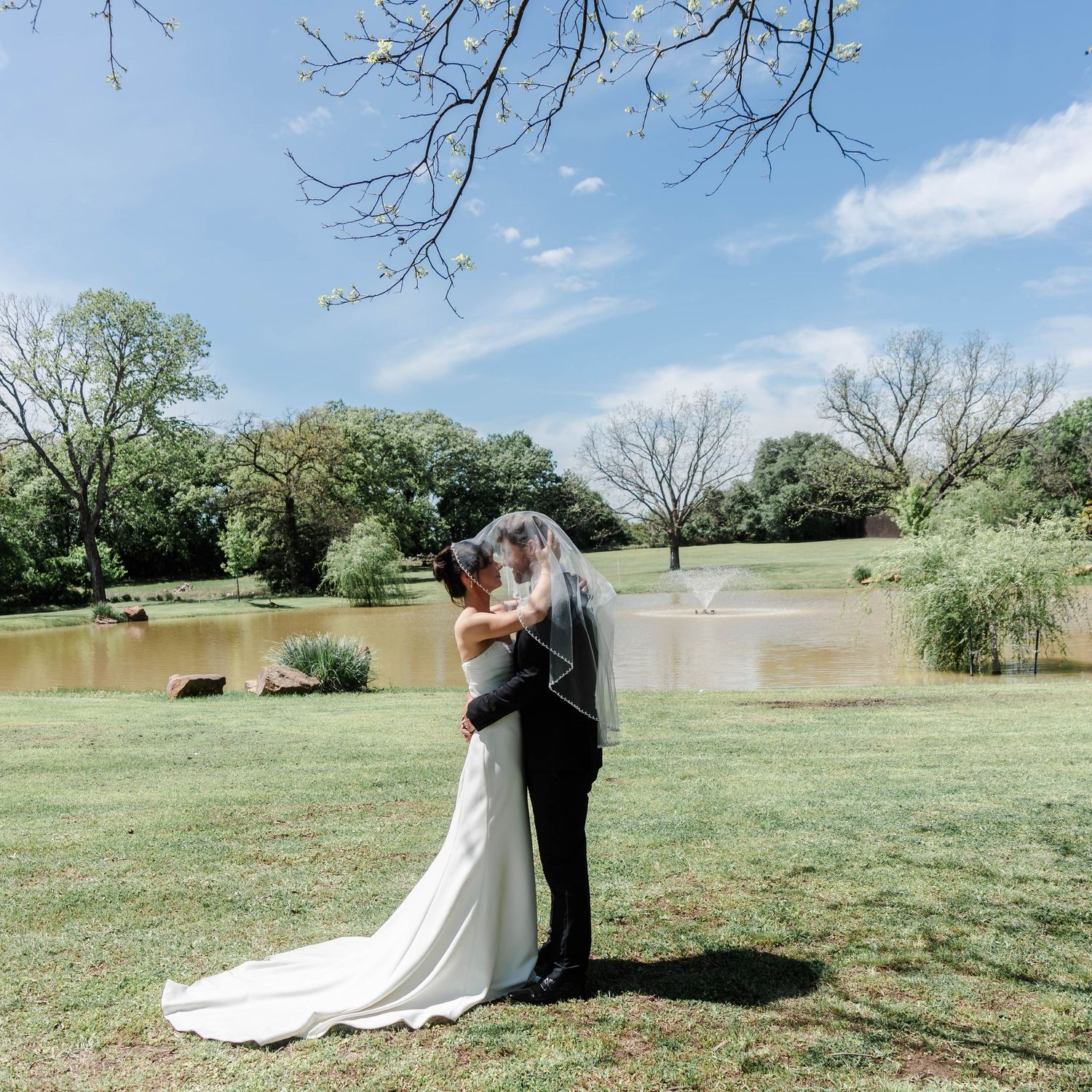 A couple's portrait near the pond outside of the ceremony space
