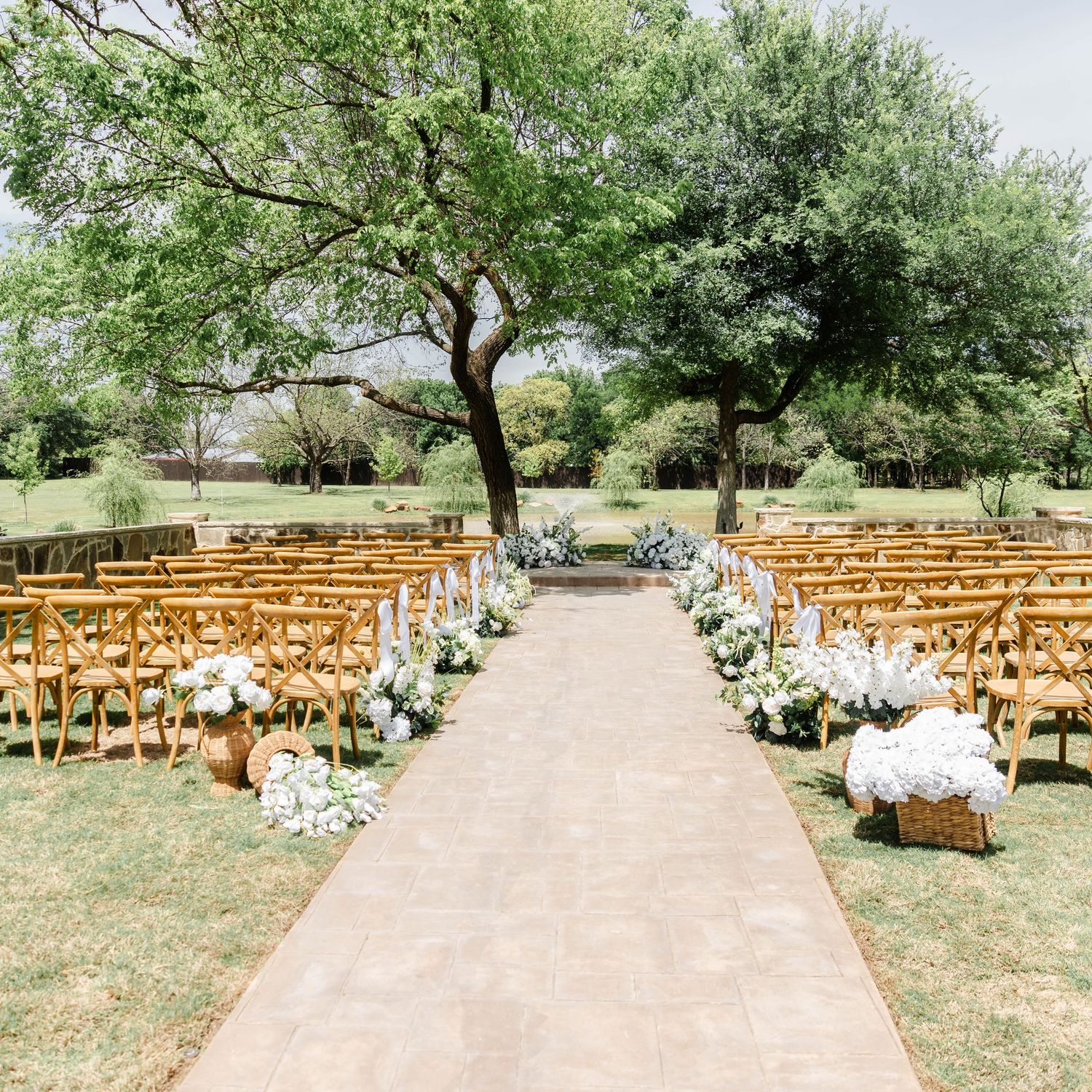 Ceremony space with white florals near a pond