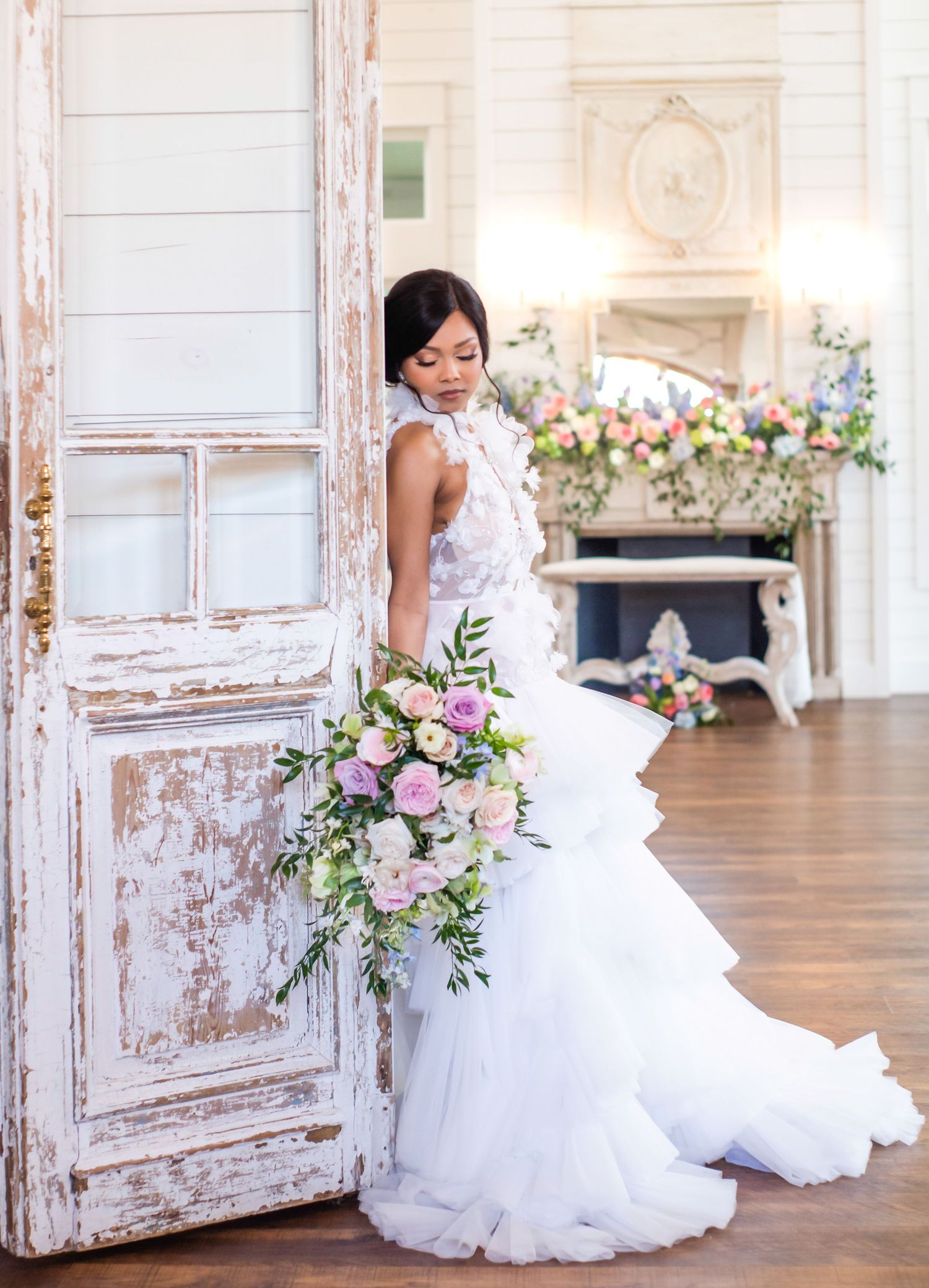 A bride looks towards her bouquet of flowers in her wedding dress