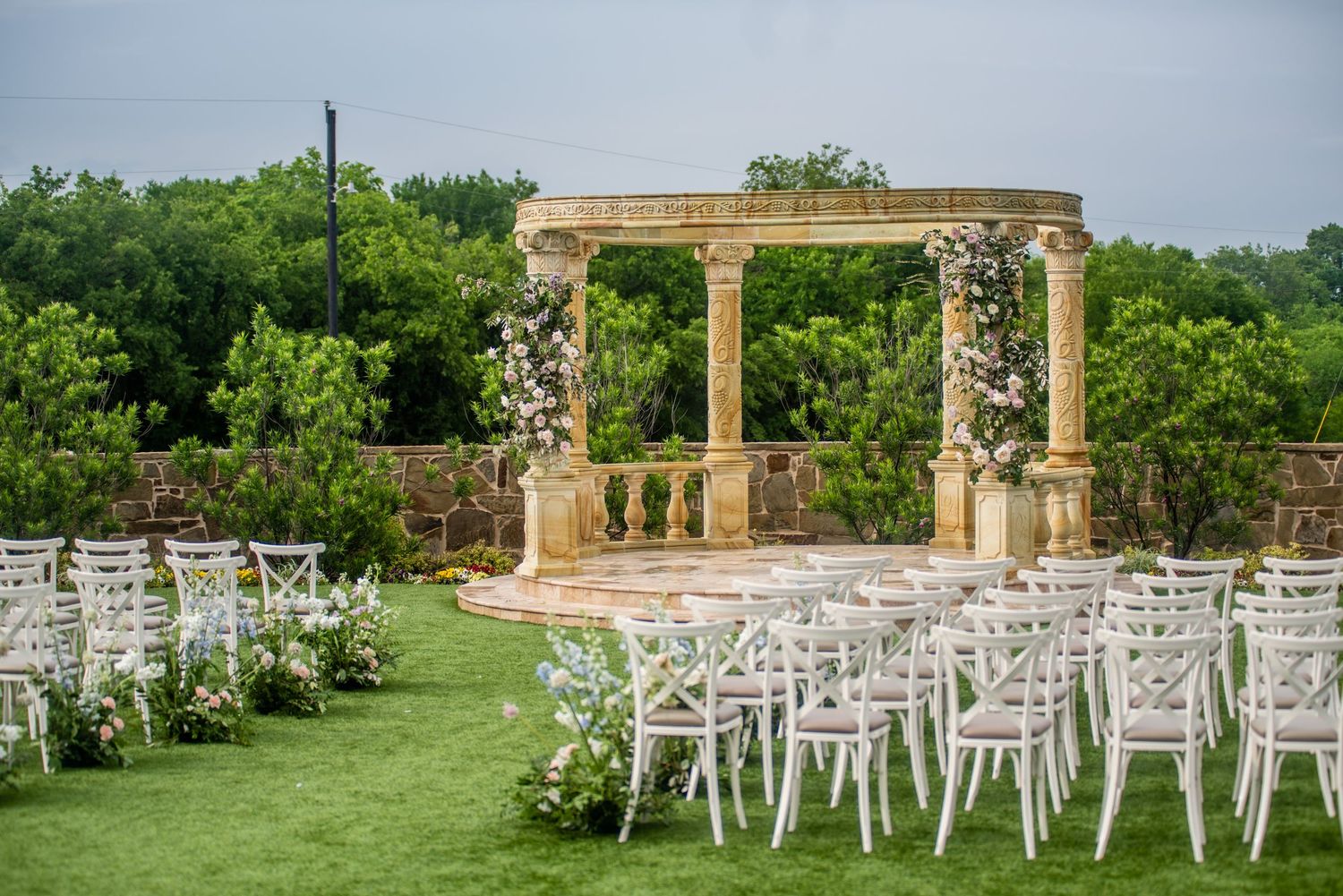 A ceremony set up for a wedding with colorful florals and chairs.