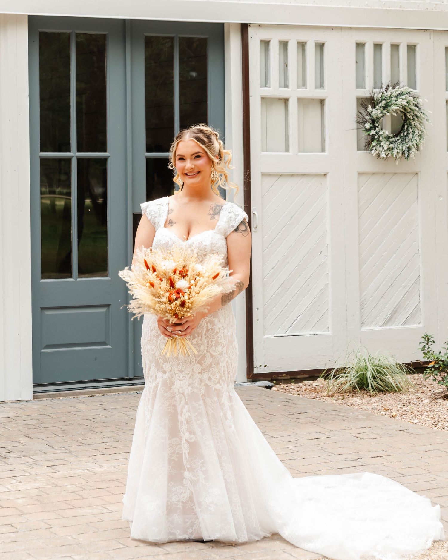 A bride stands at the front of a wedding venue holding her flowers
