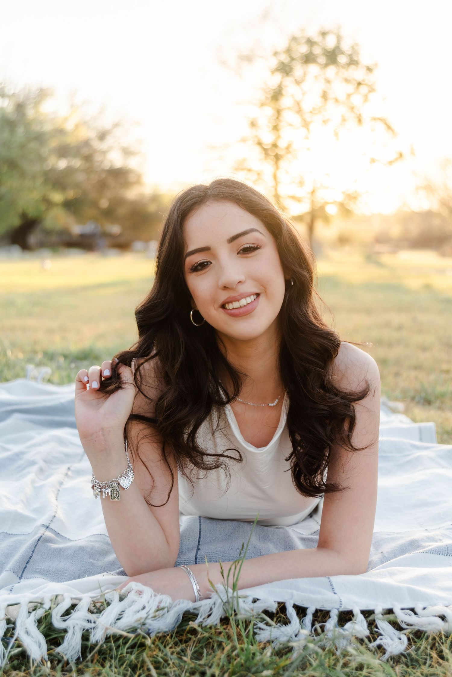 a young woman laying on a blanket holding her hair