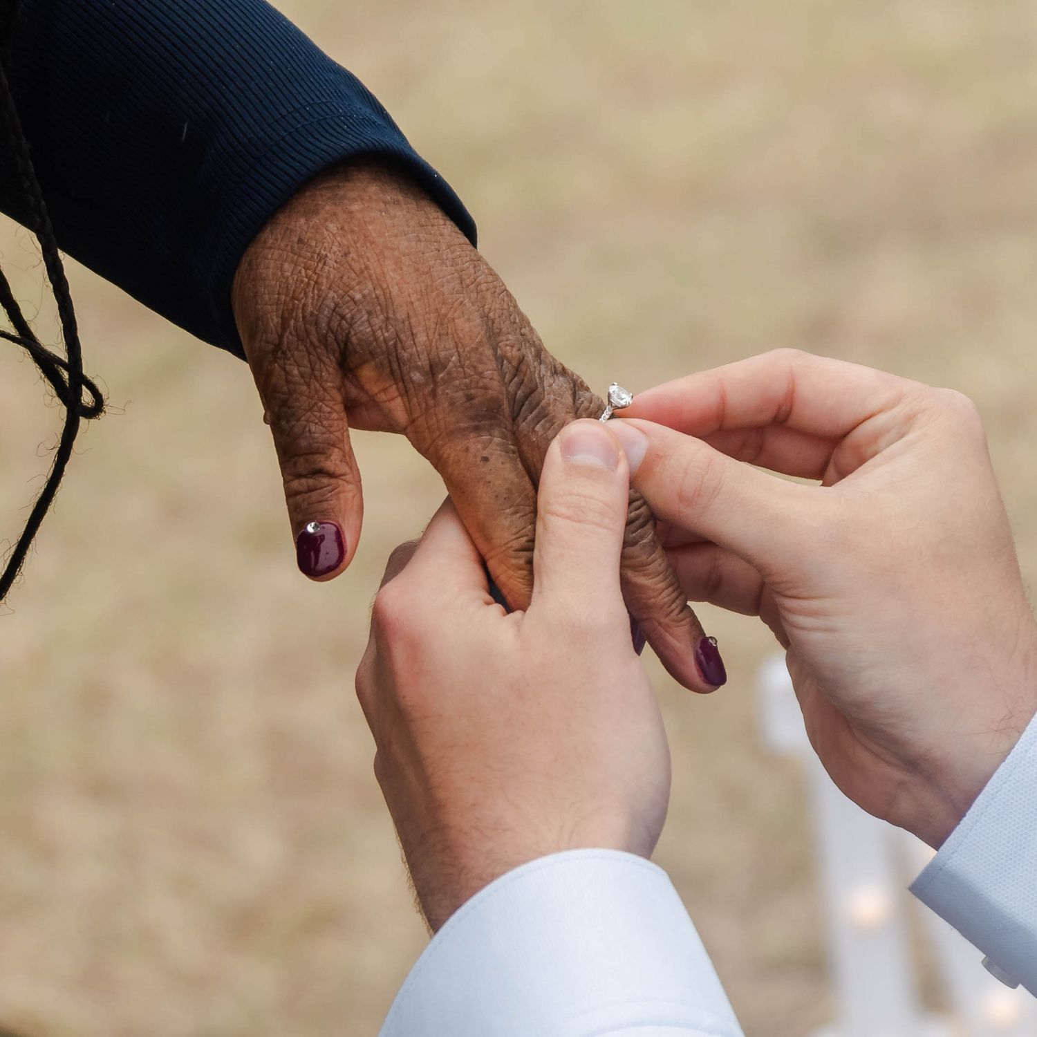 a hand placing a ring on another hand