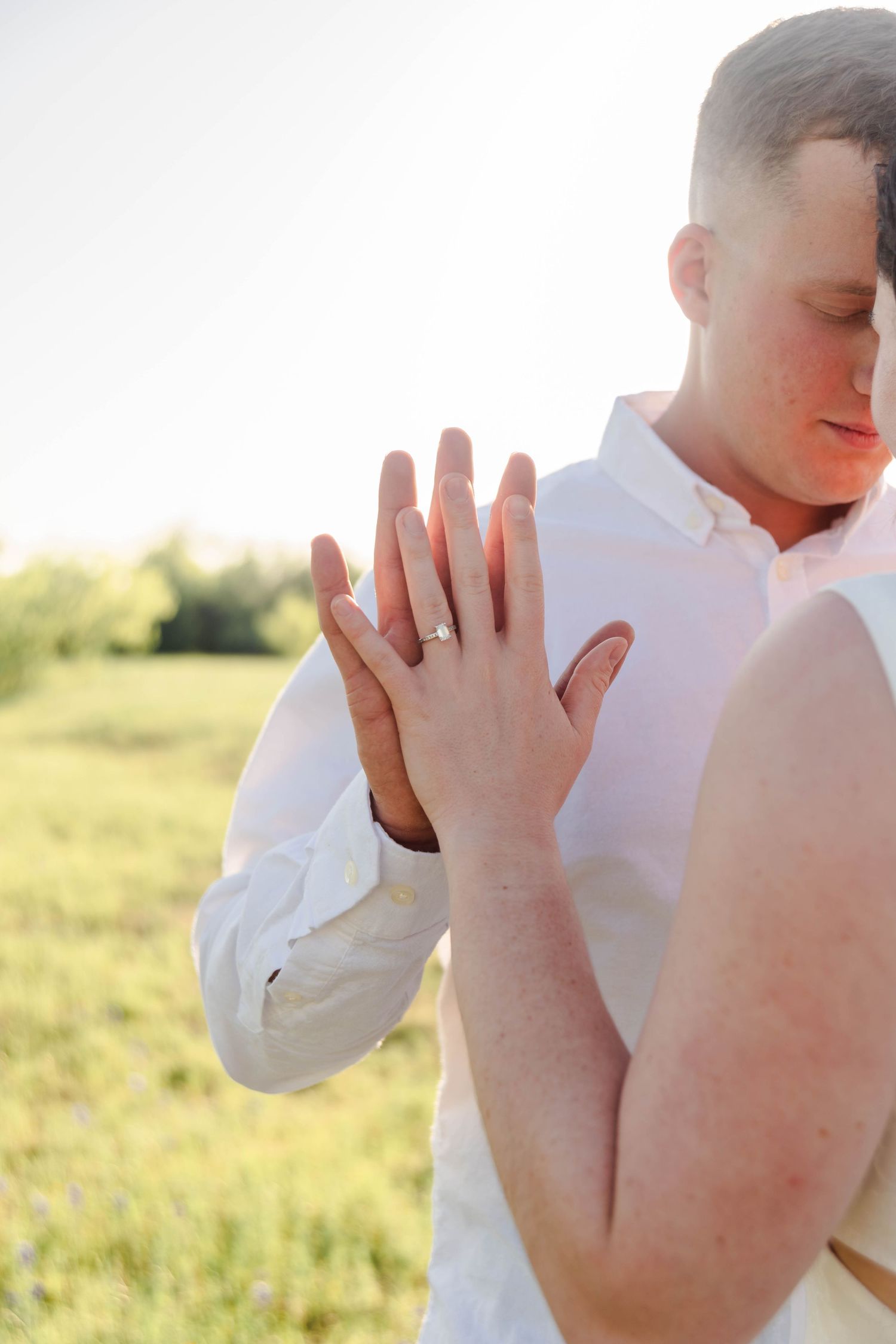 couple standing with their eyes closed holding their palms together