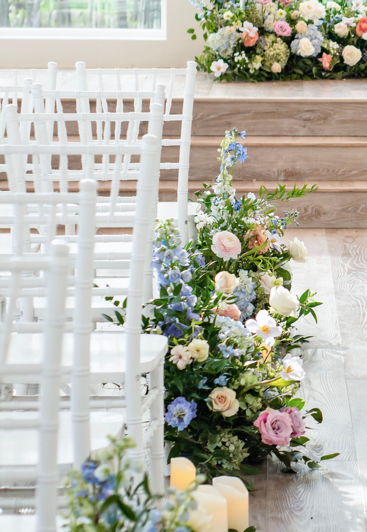 Floral arrangements at the ends of chair aisles in a ceremony
