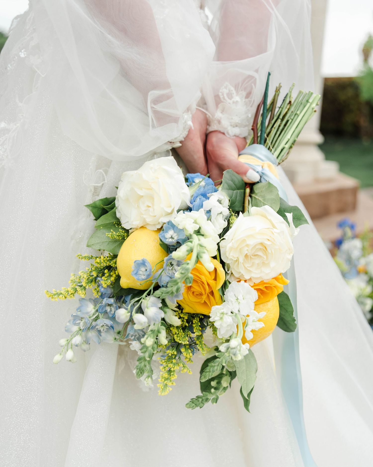 a bouquet with yellow, blue, and white florals with lemons