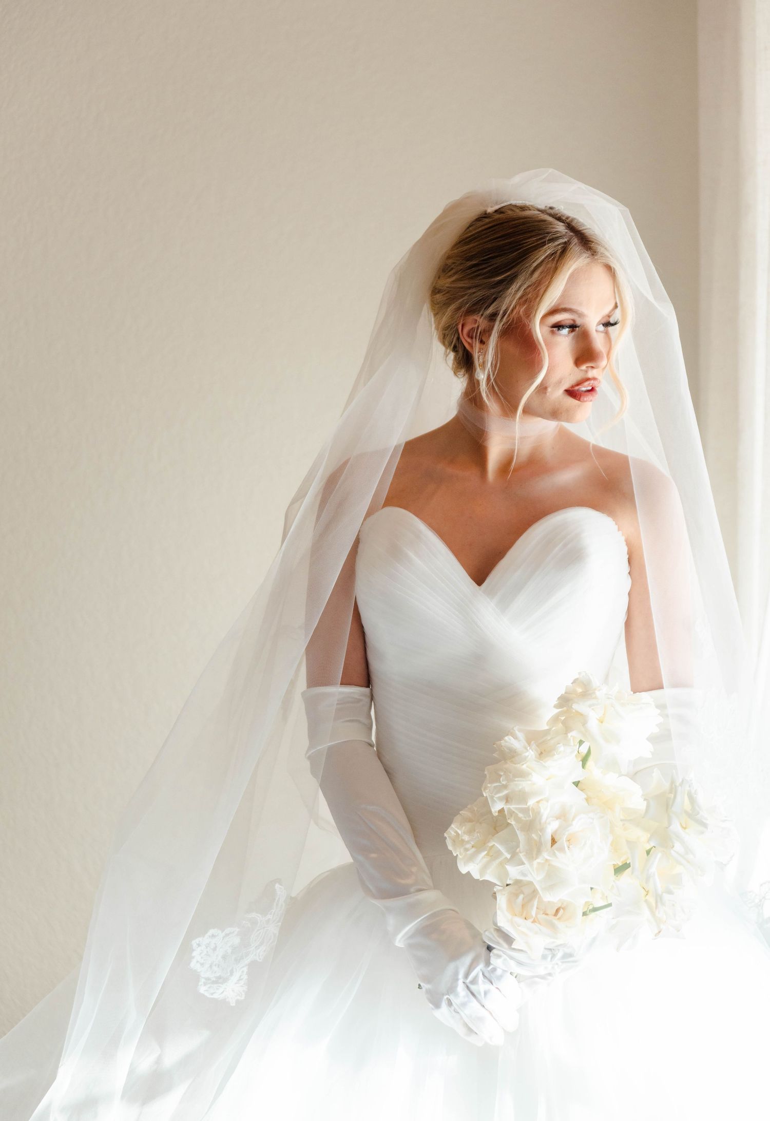 a bride looks out a window