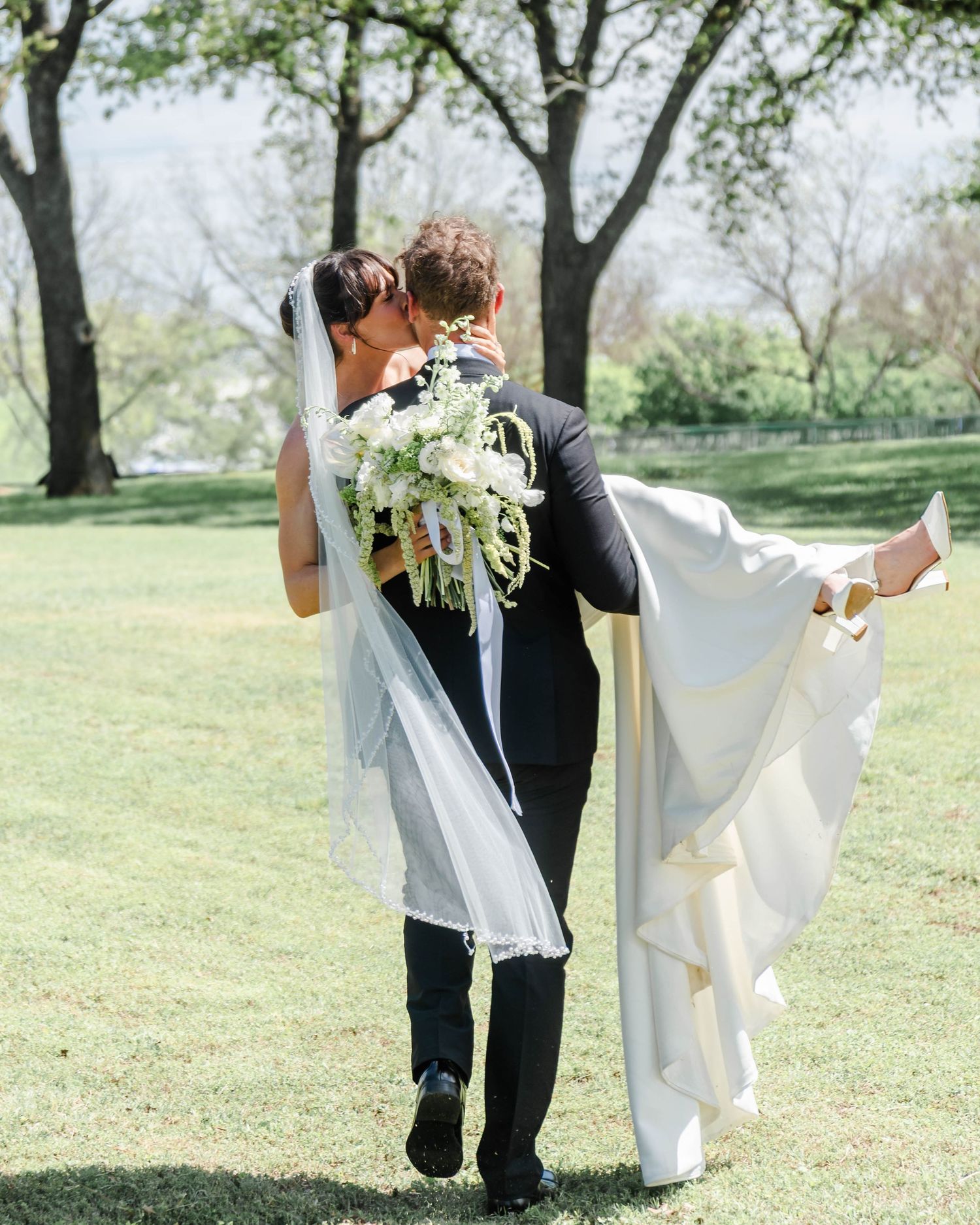 a groom carries his bride off