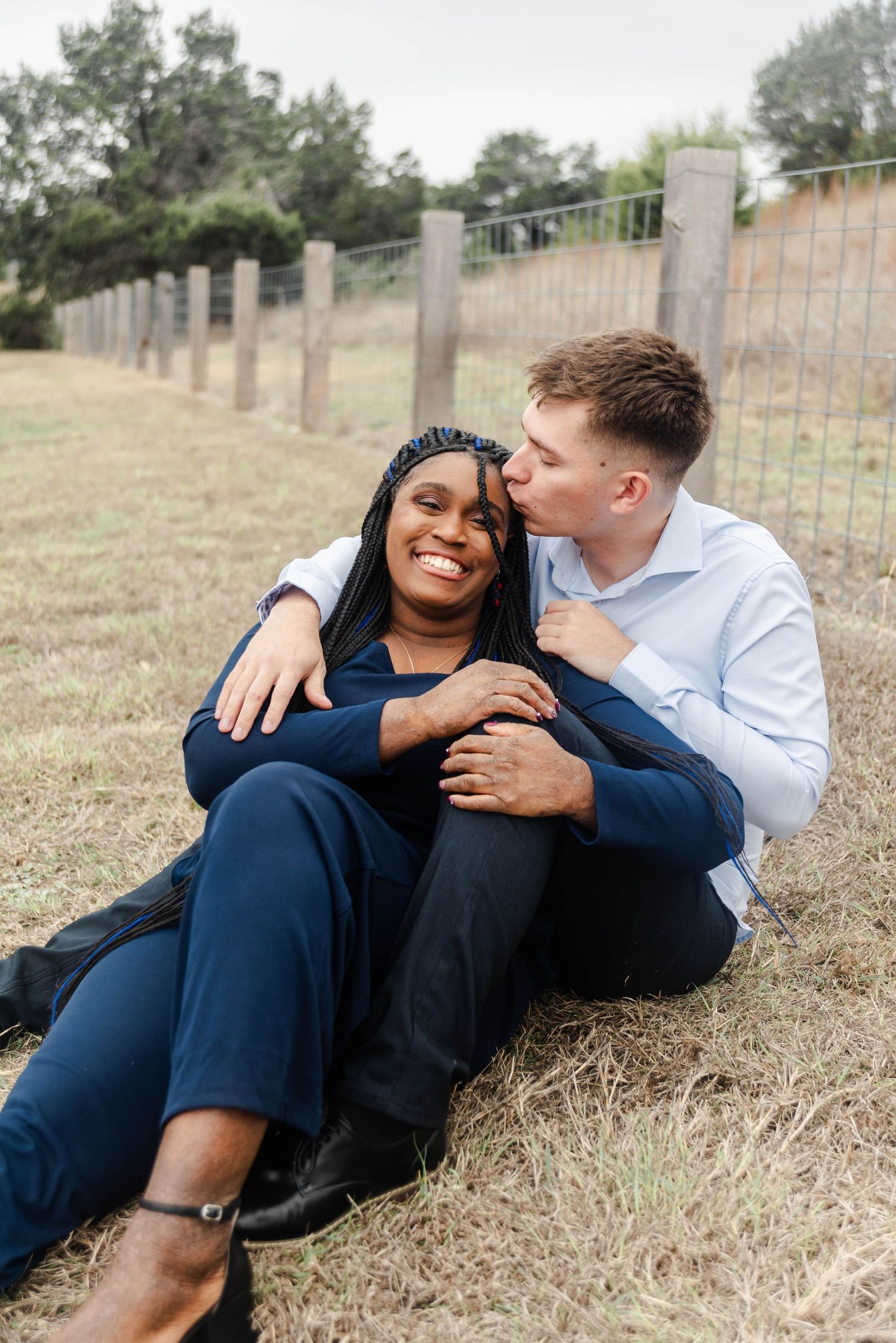 man kisses a woman on the side of her head