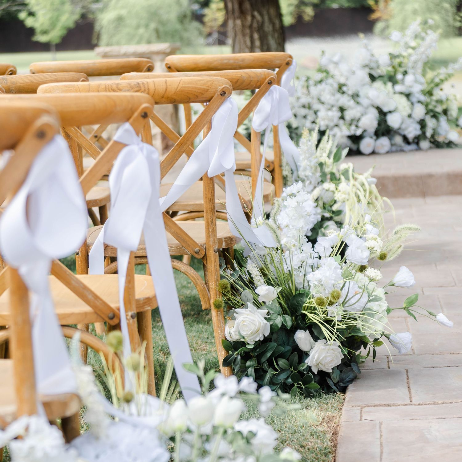 details of chairs with ribbon and white florals