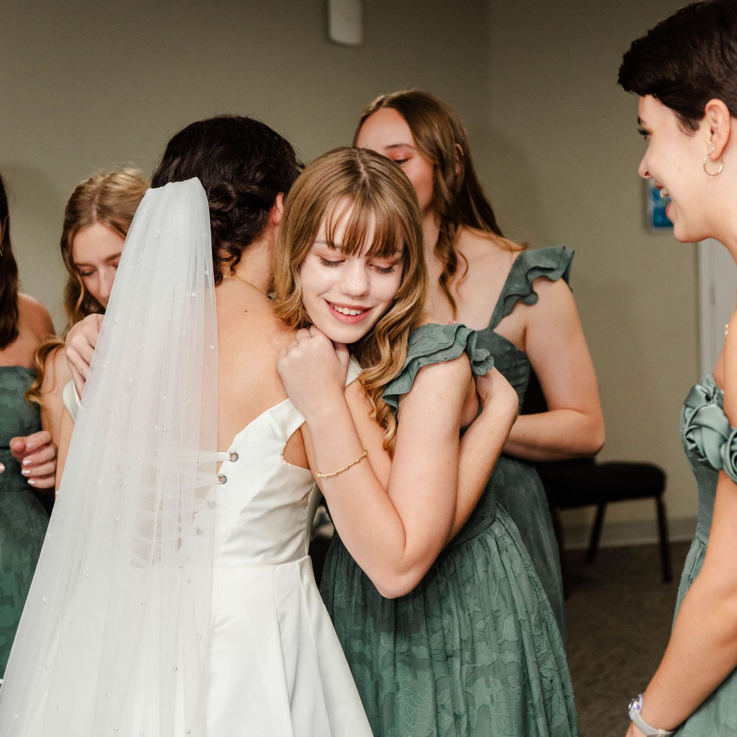 bride gets a hug from a bridesmaid