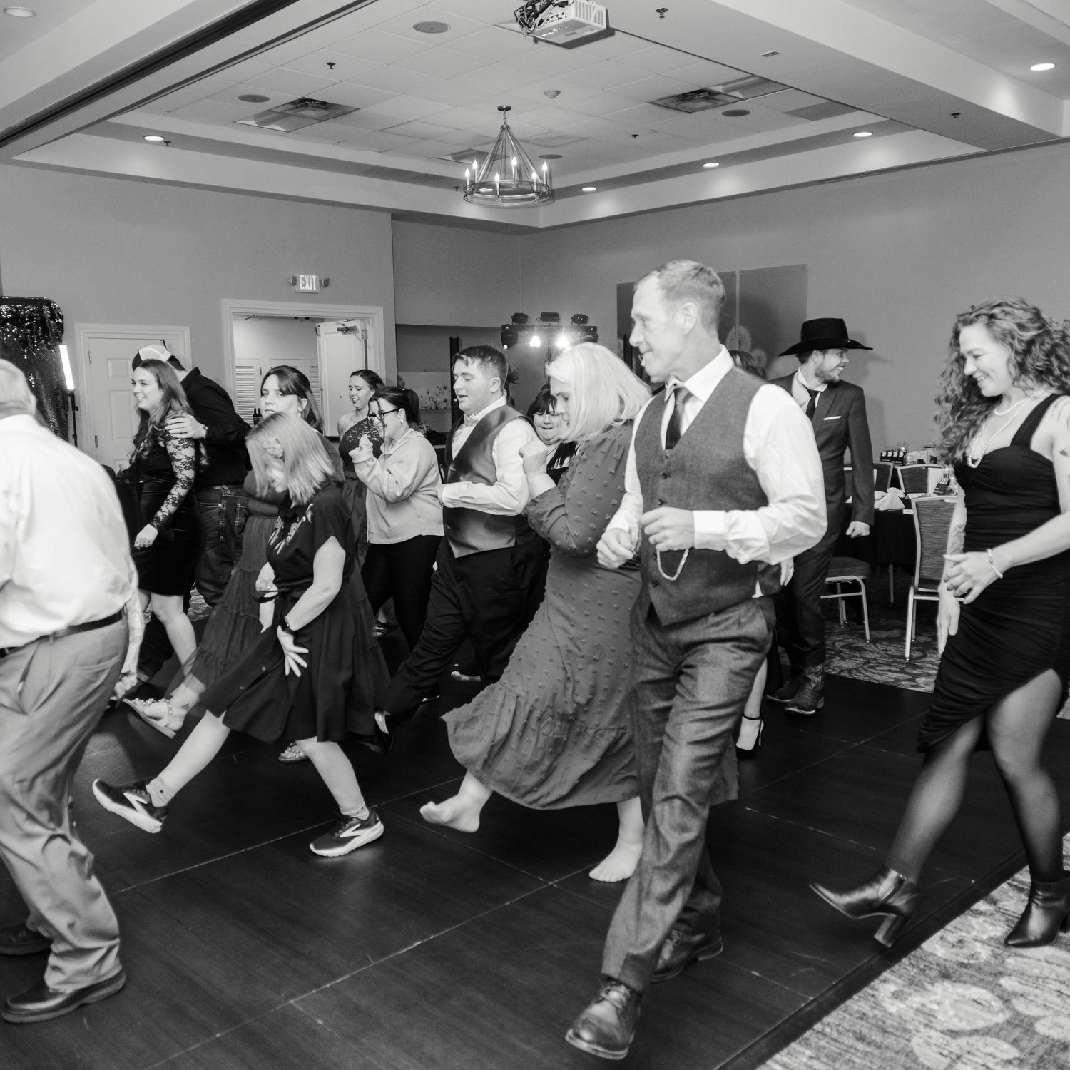 A dancefloor is full of people doing a line dance.