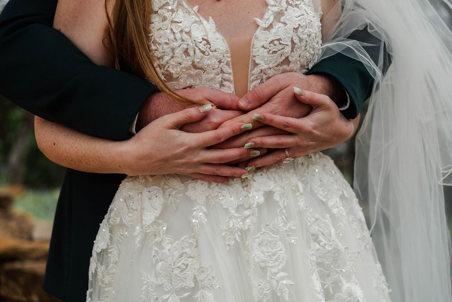 bride and grooms hands wrapped around the bride