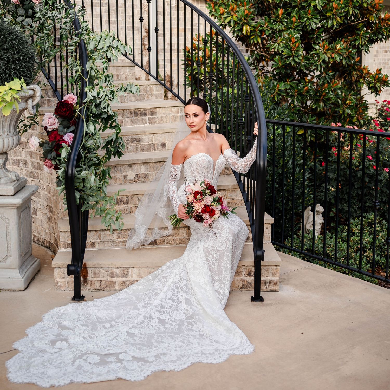 a bride sitting on the staircase with her bouquet