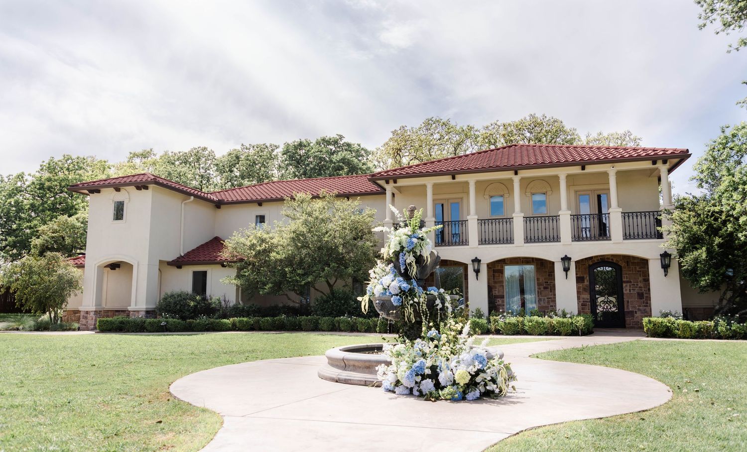 Tuscan Oaks Estate front of venue with blue florals at the fountain