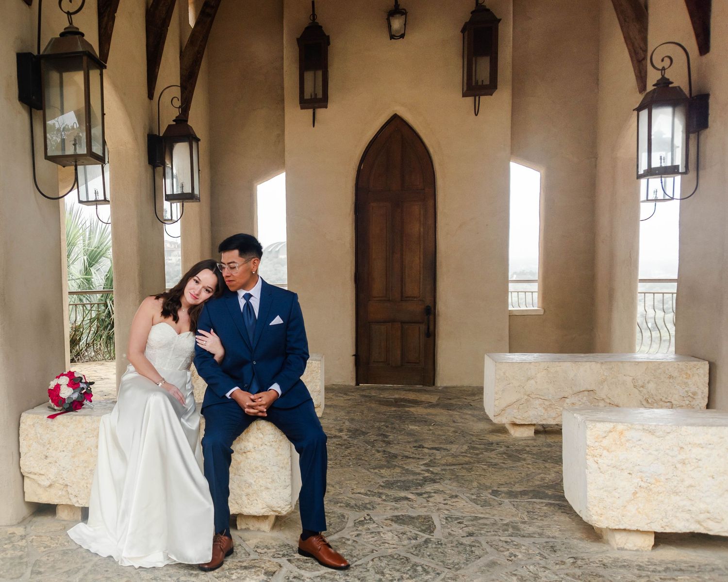 A couple sits together in an outdoor chapel