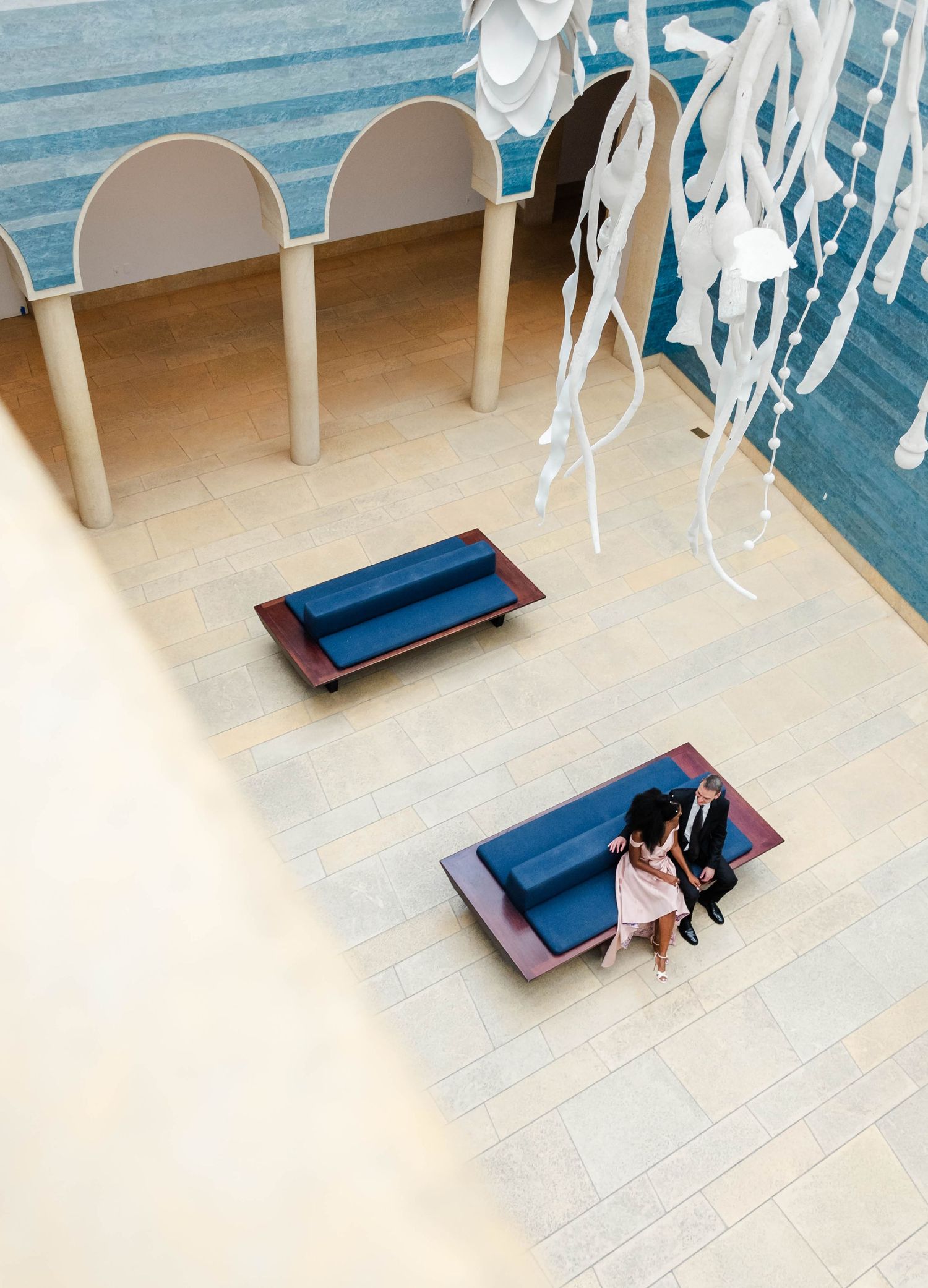 A couple sits together on a bench inside The Blanton Art Museum