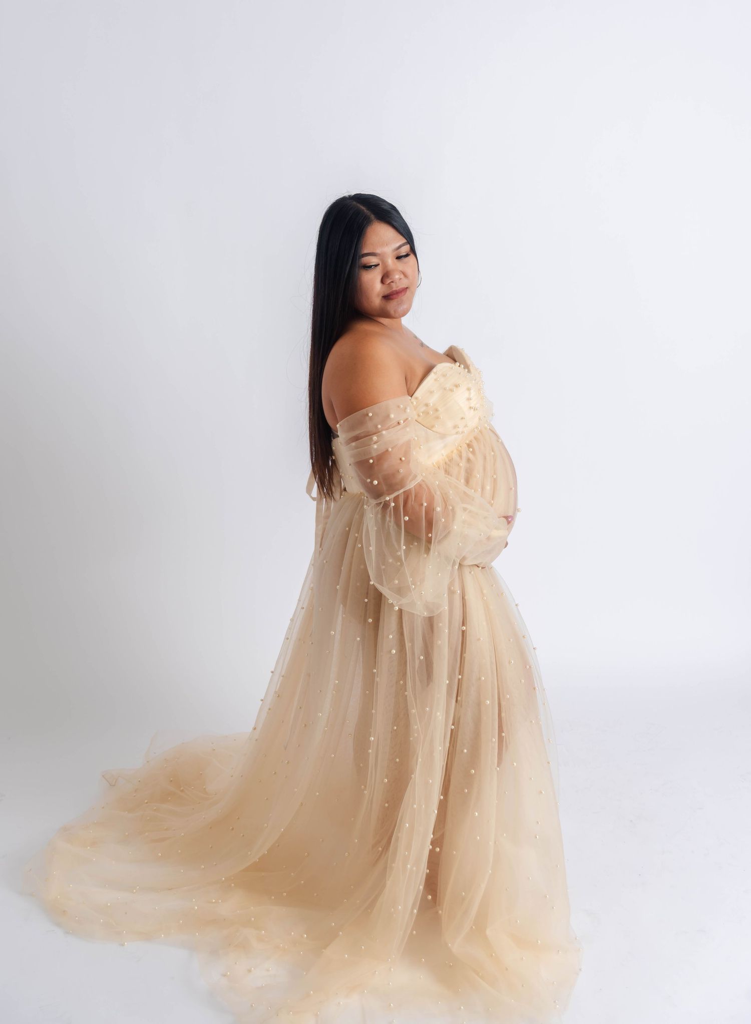 a woman that is pregnant poses for a photo holding her baby bump
