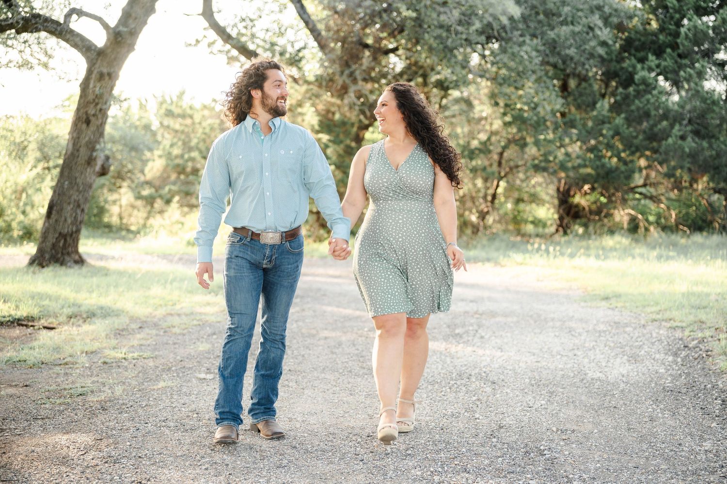 a couple walks together in a tree grove