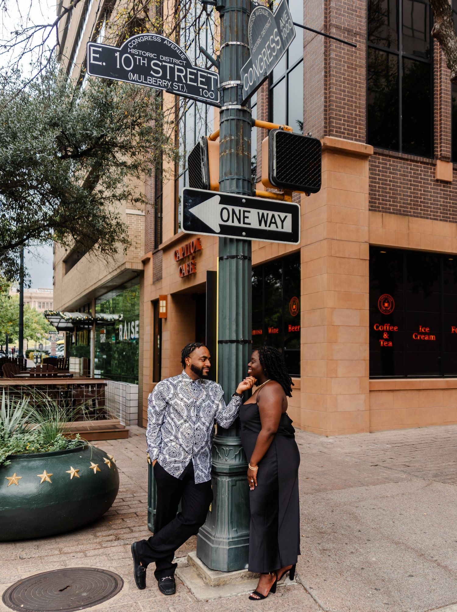 a couple stands at a street post in downtown Austin