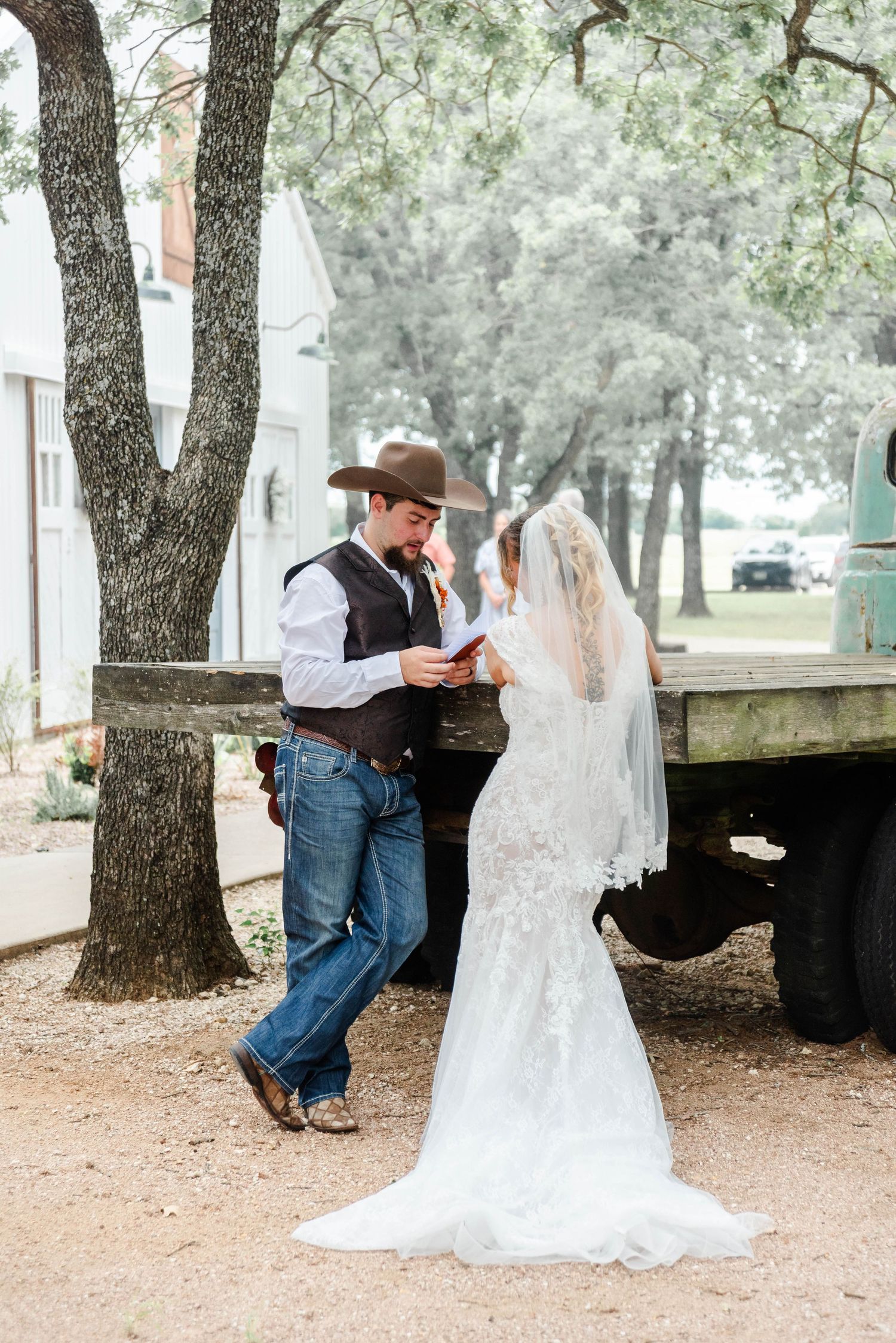 a bride and groom have a private vow reading at an old truck
