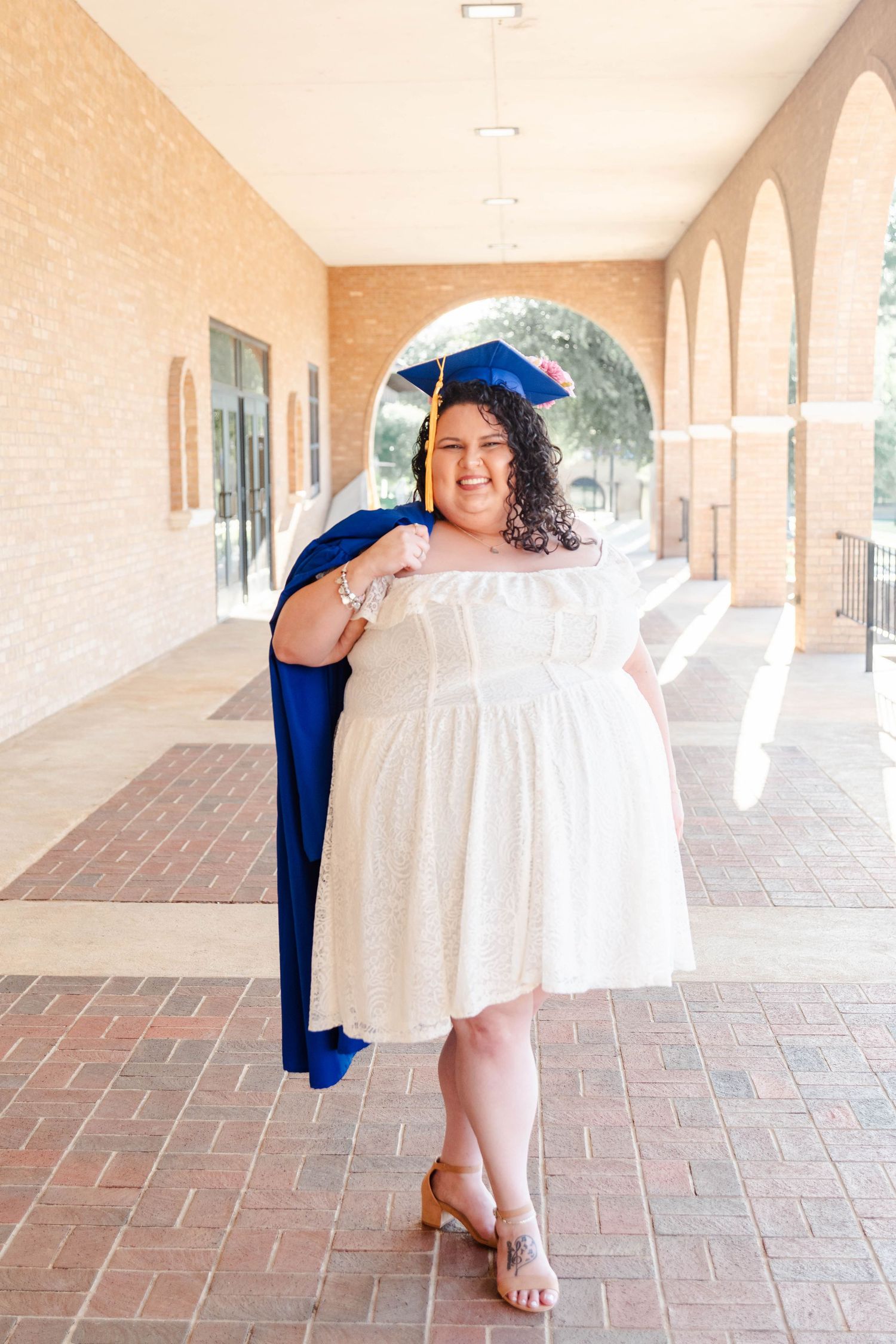 a female holds her cap and gown for graduation