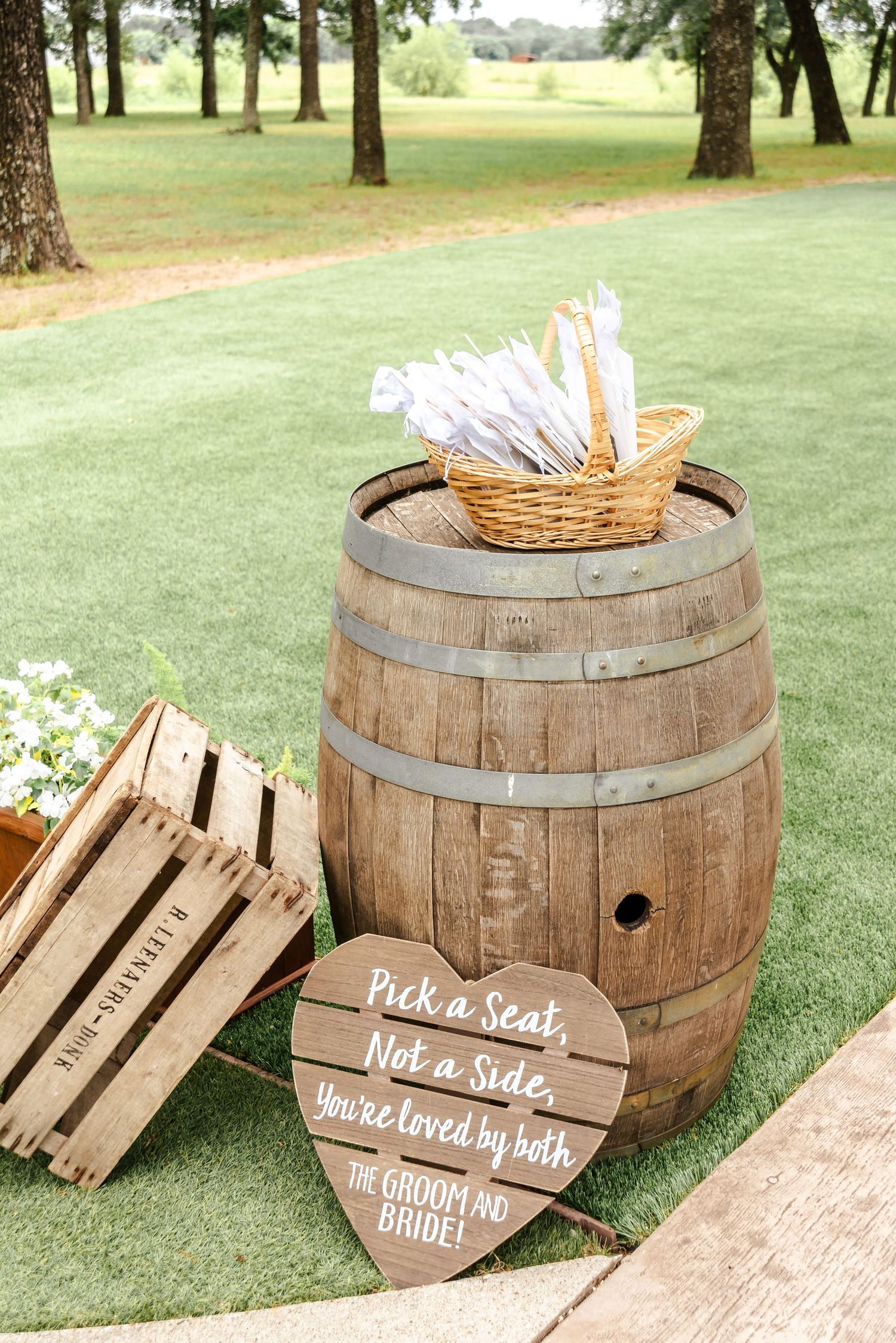 Wine barrel with guest fans and signage for a wedding