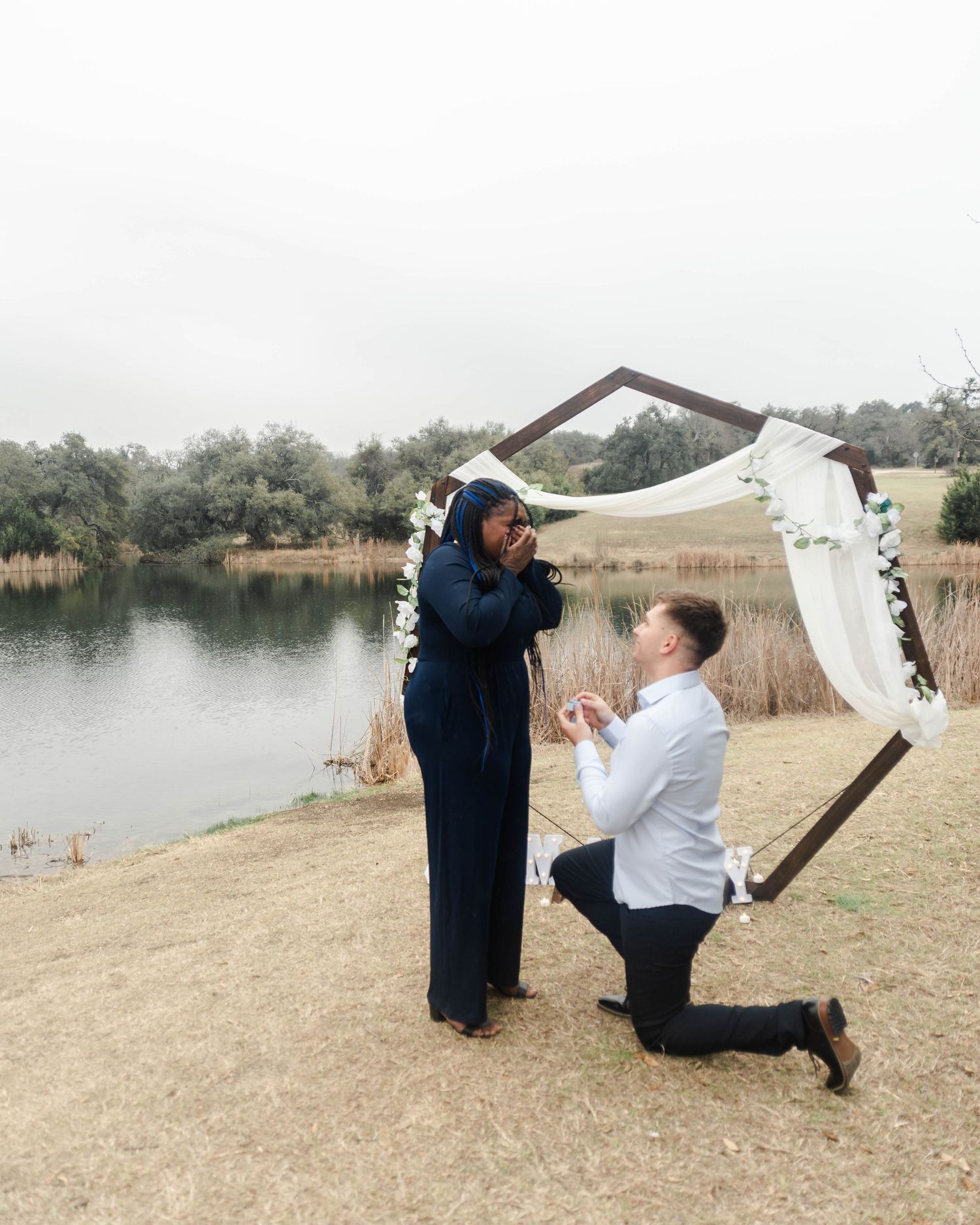 a man is proposing on one knee to a female