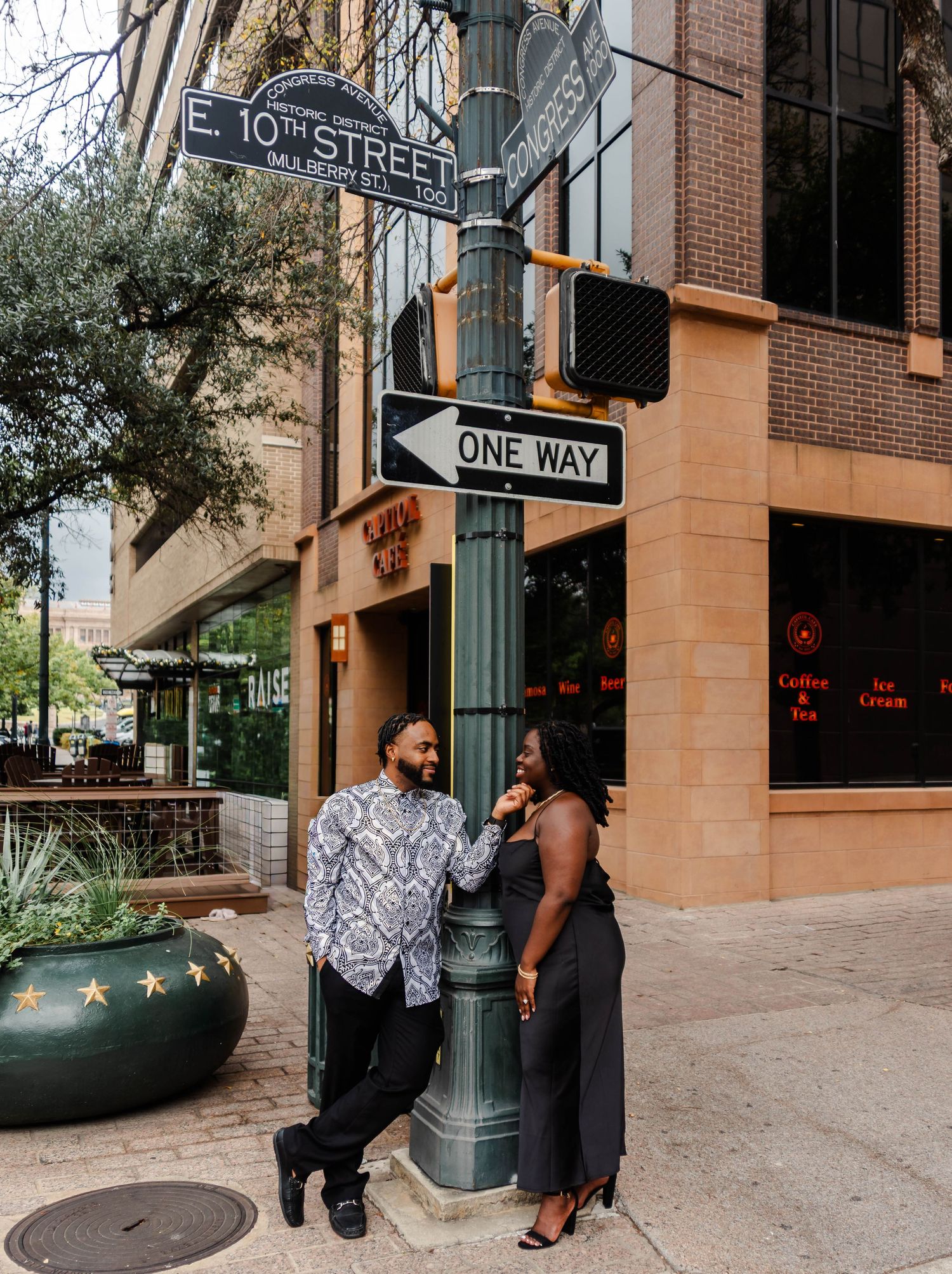 couple standing near a street sign smiling