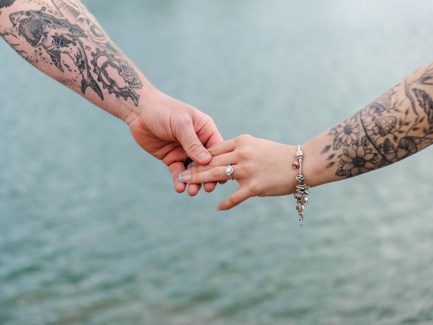 a couple shows off an engagement ring on the woman's hand