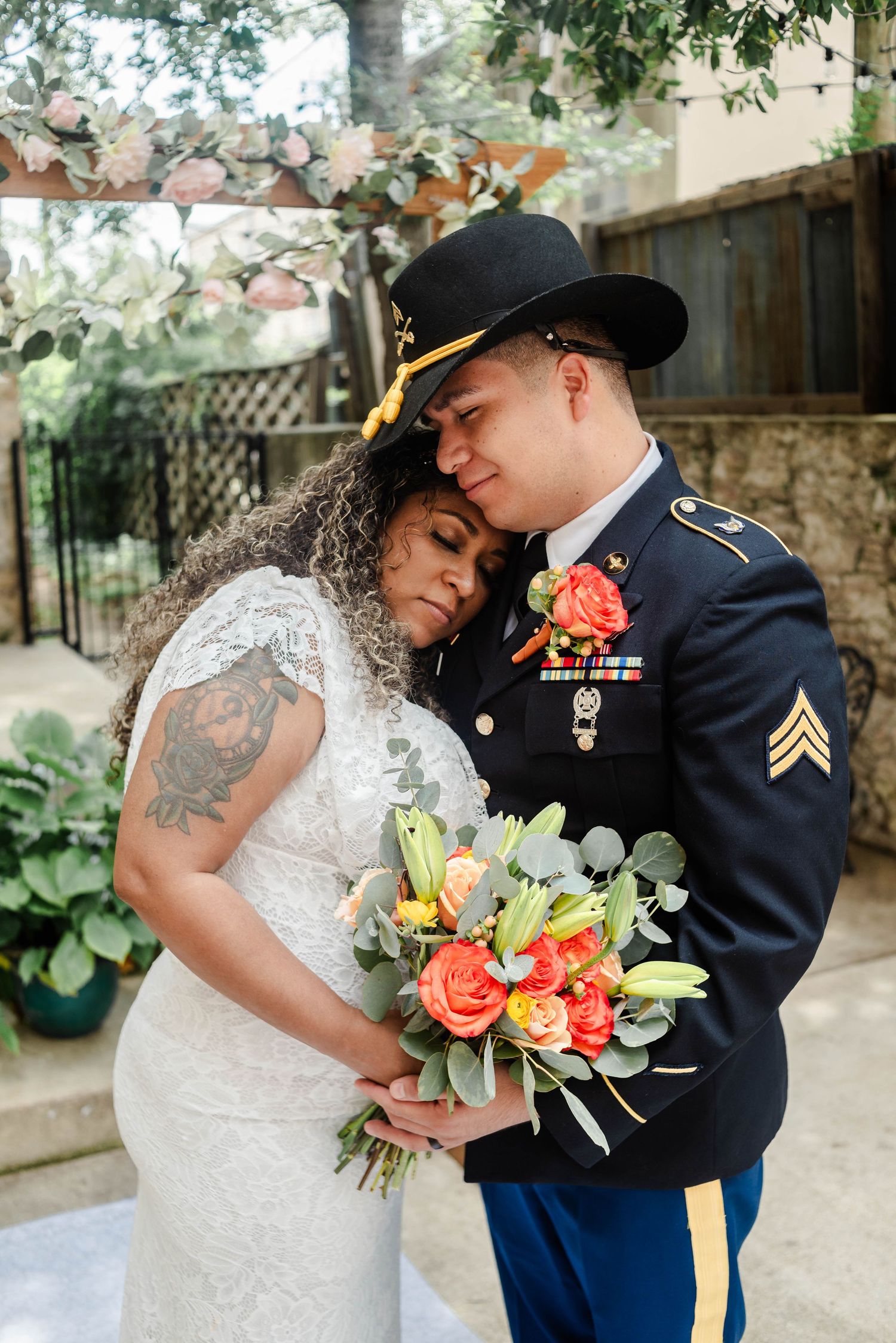A military couple stands close together for photos