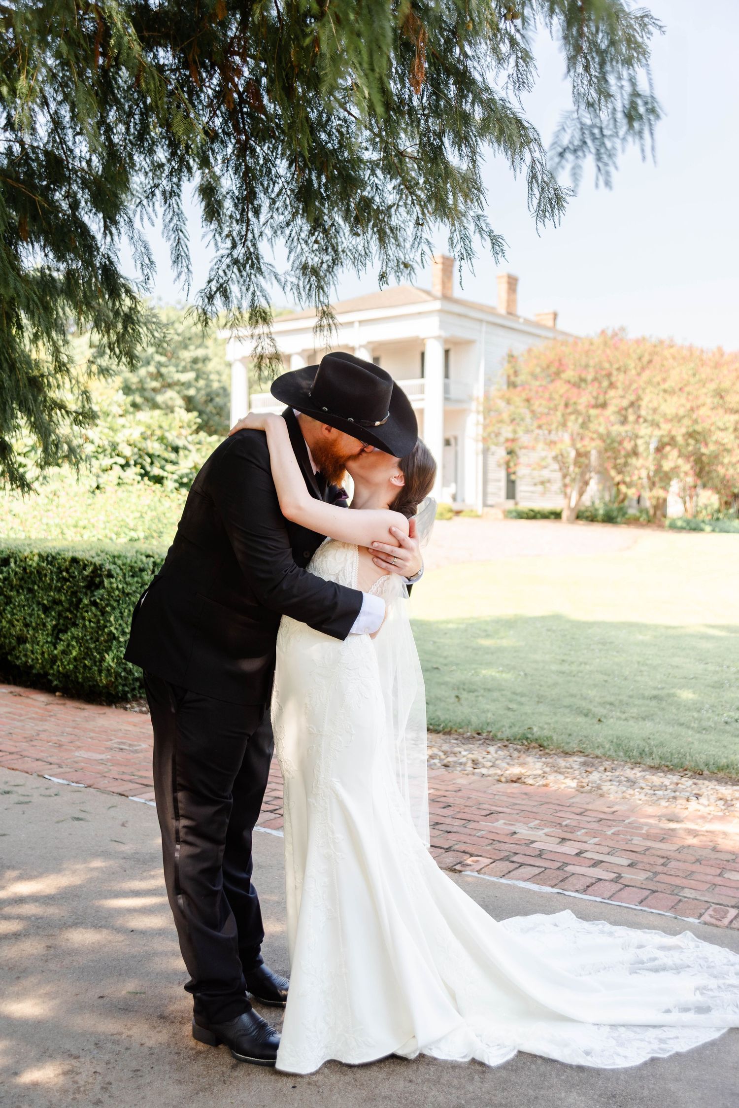 a couple kissing in front of their wedding venue