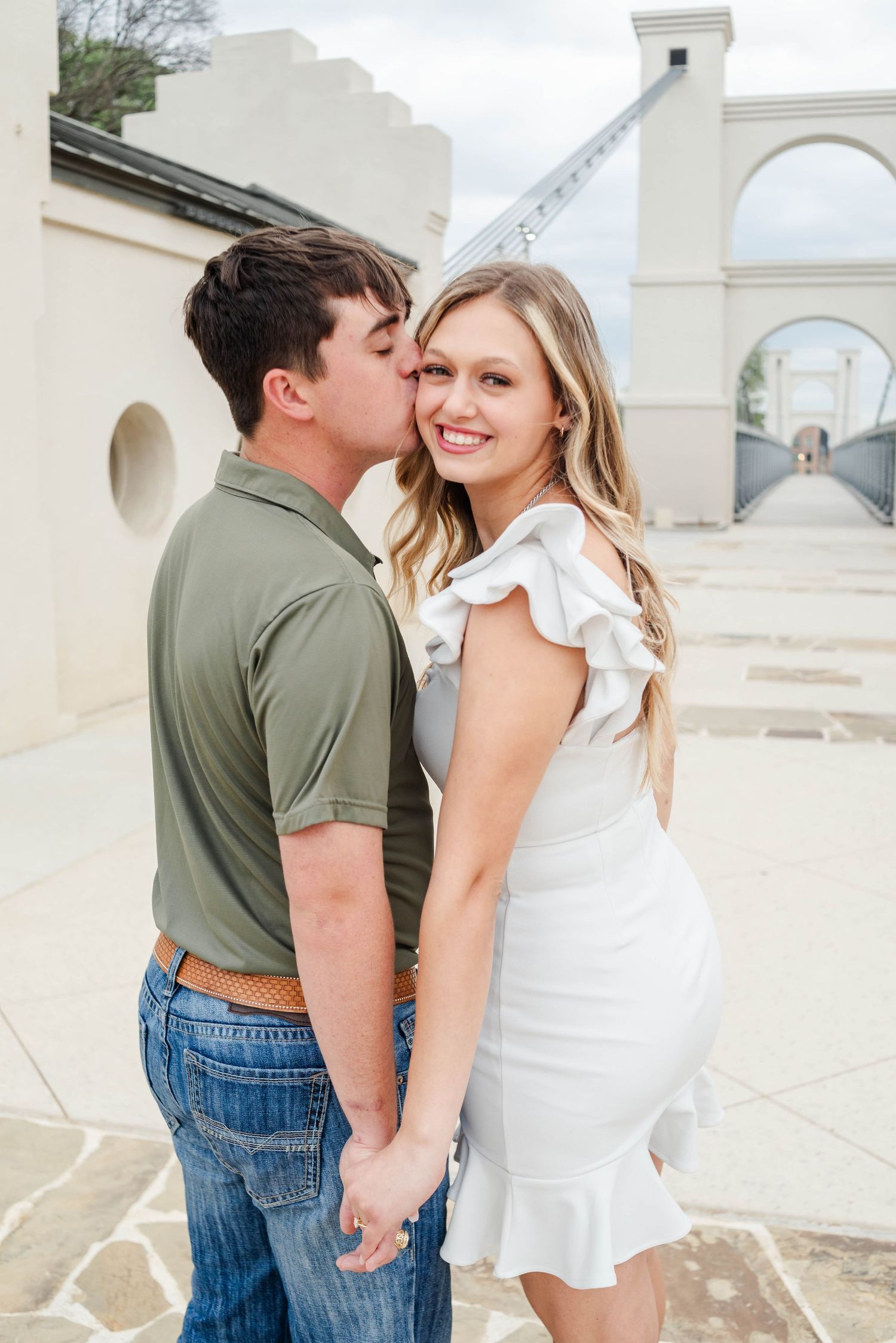 Couple holding hands at Waco Suspension Bridge in Waco, Texas