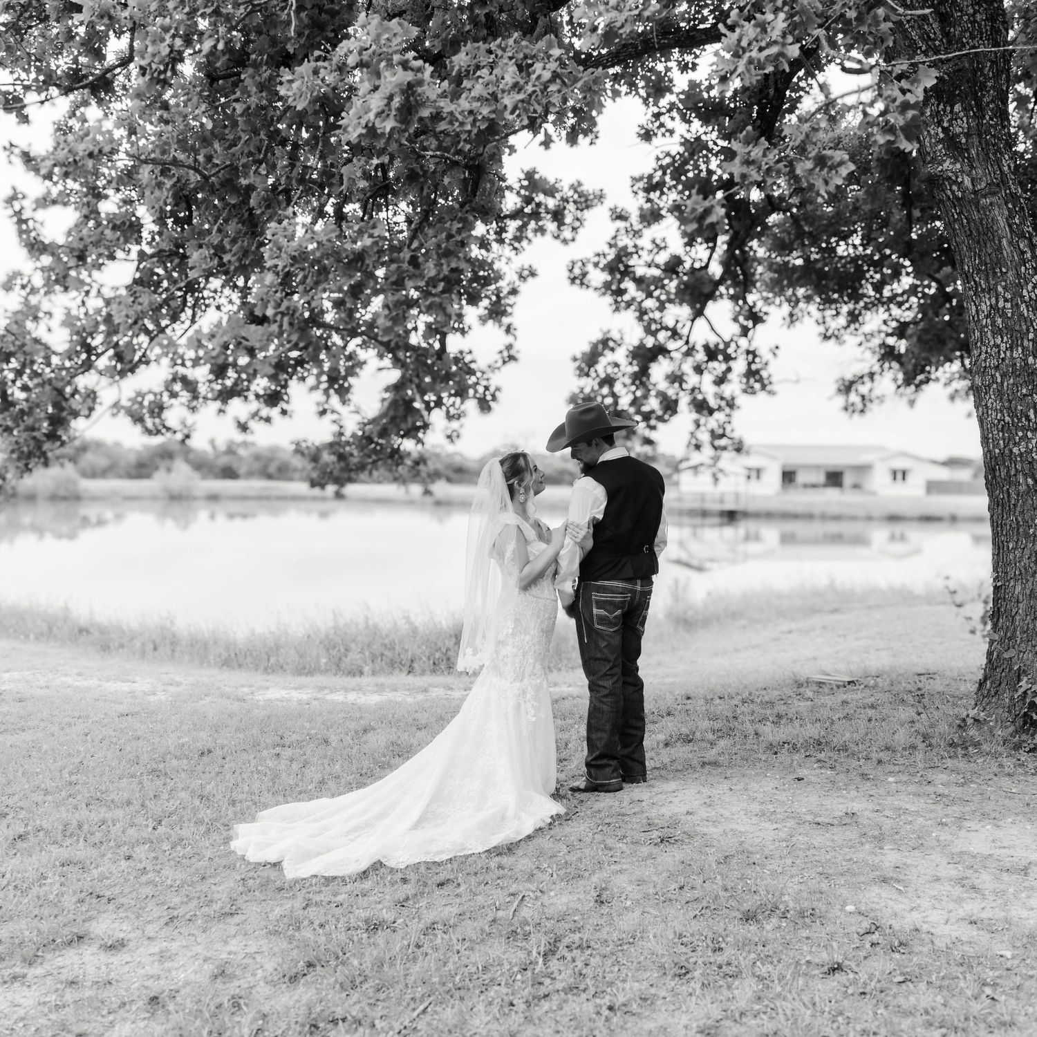 A couple stands beside a tree looking lovingly at each other
